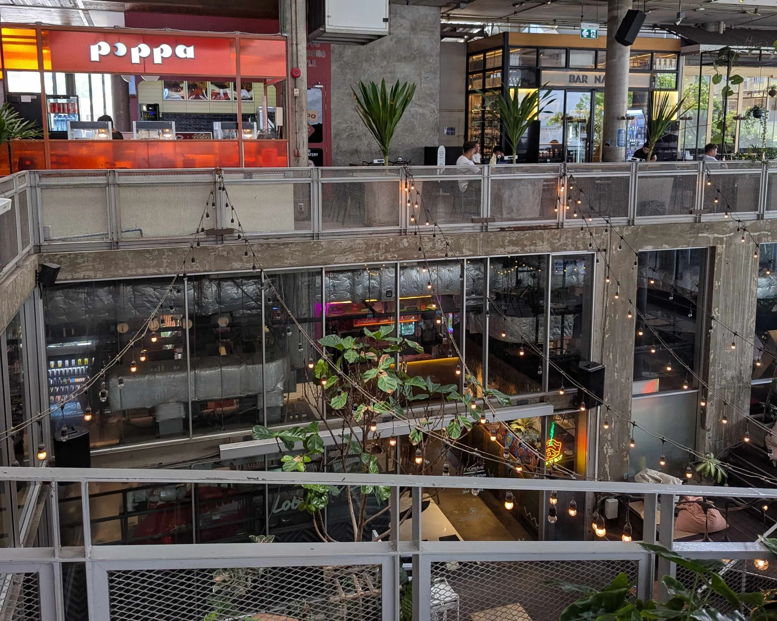 An outdoor community space with restaurants and outside lighting