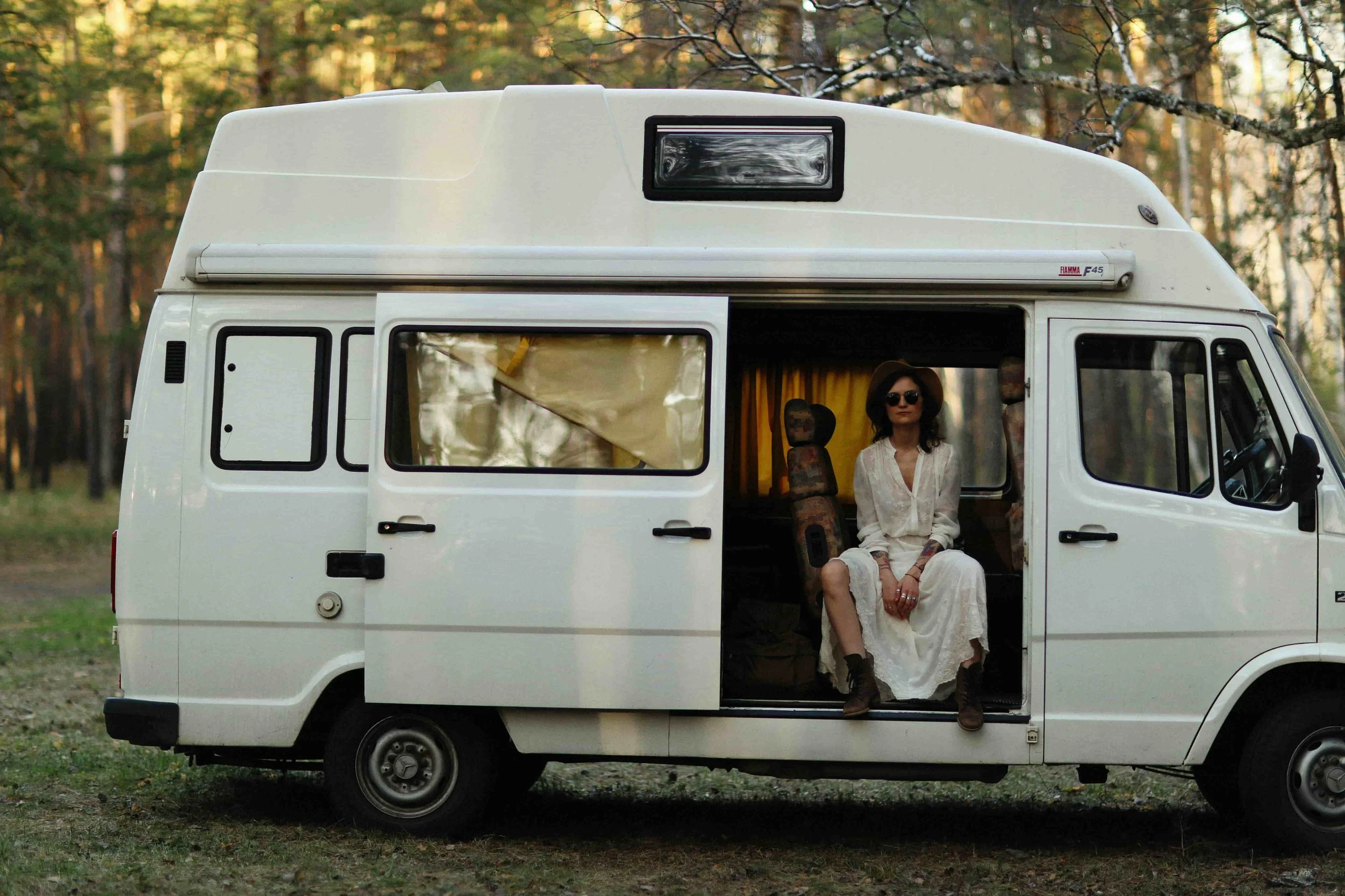 A woman in the woods in a campervan