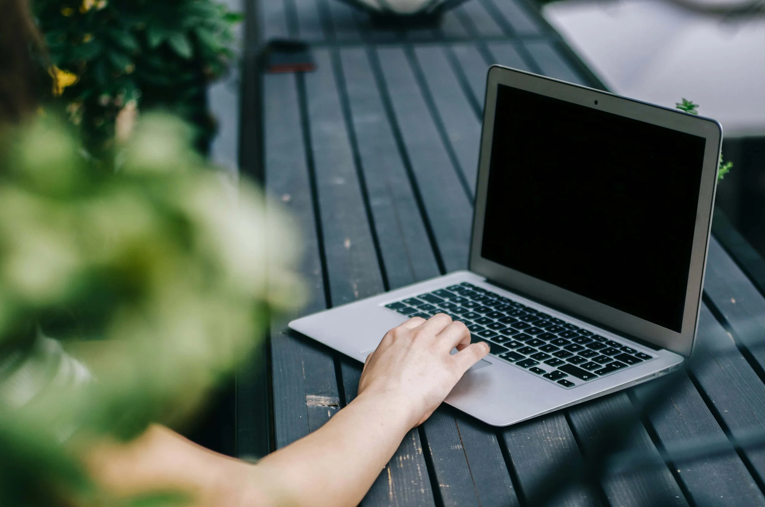 A laptop on a wooden table with an arm