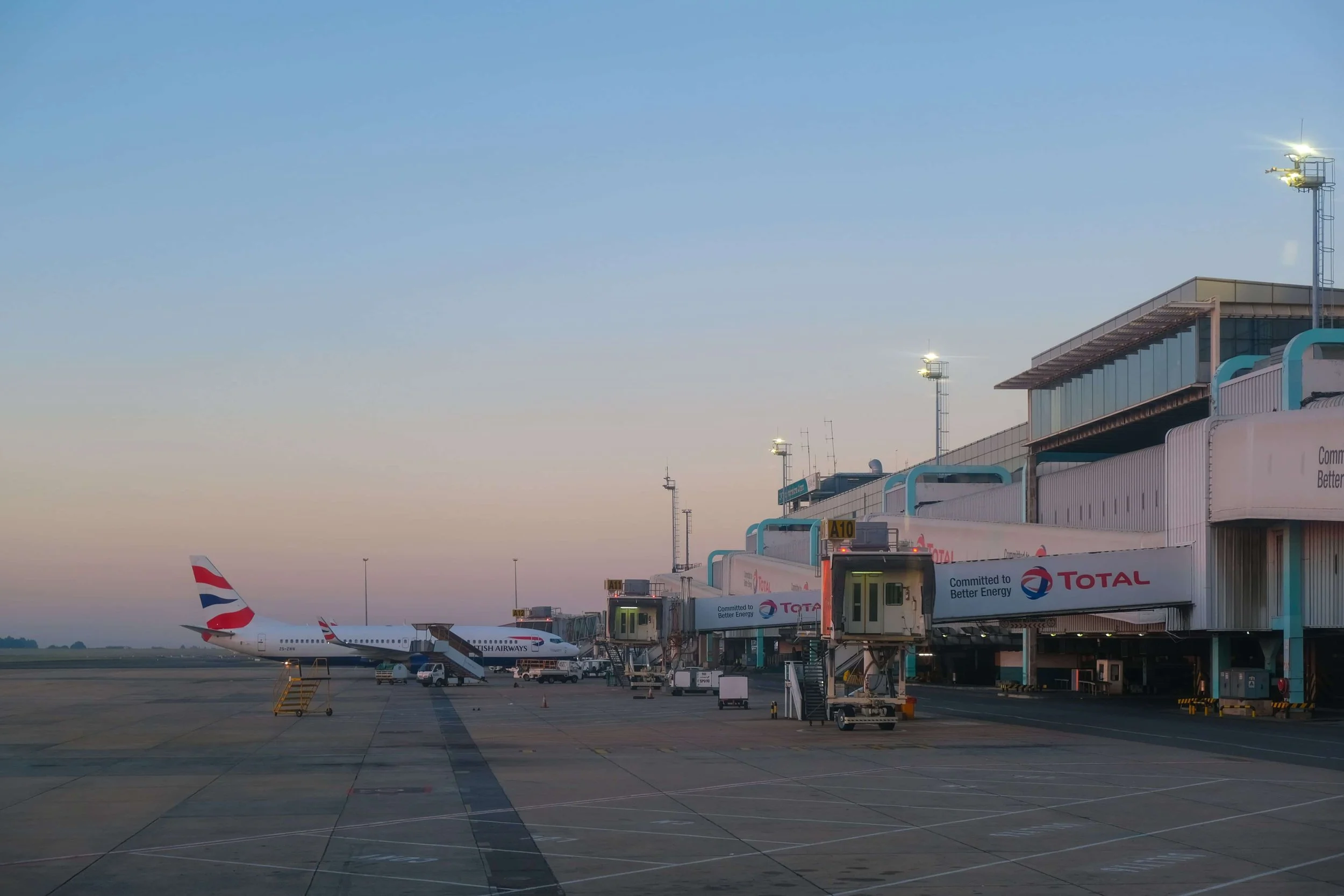 an airport terminal with a plane and gates