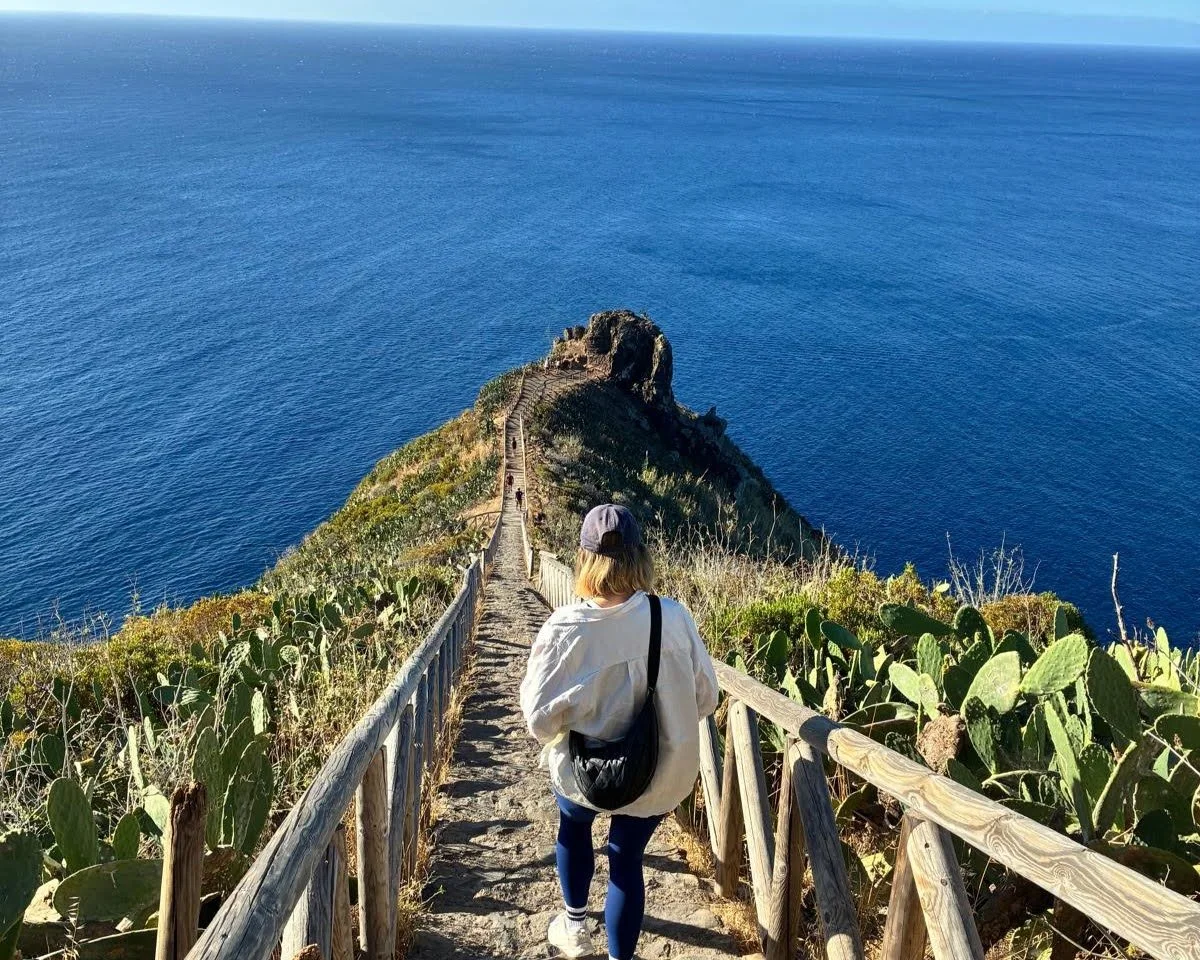 A woman walking down the stairs overlooking the sea on Madeira