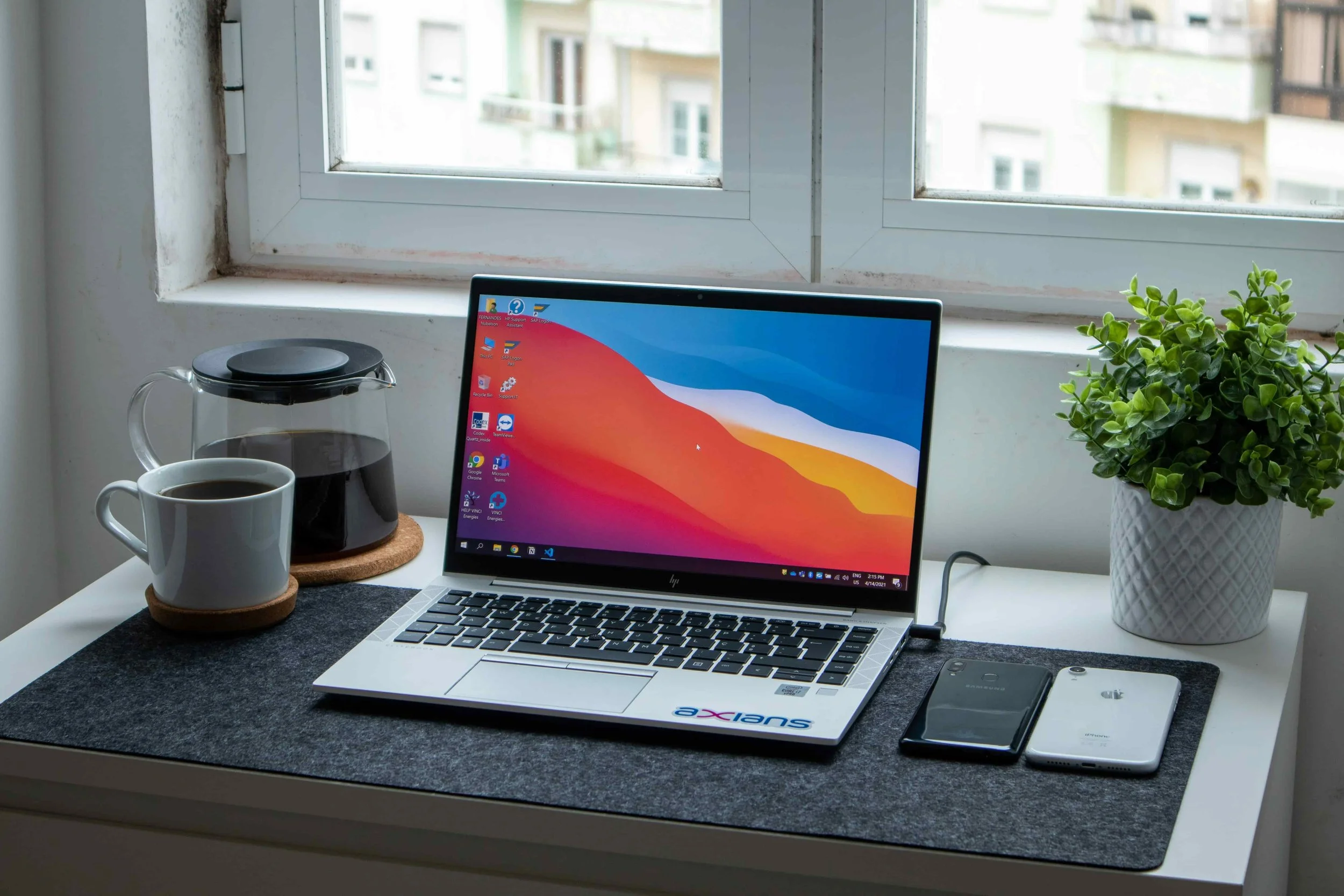 a laptop on a table with a plant and coffee