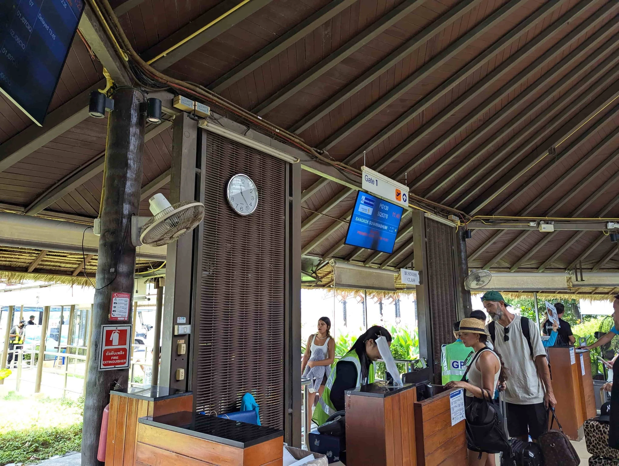 An open air gate with people boarding at Koh Samui airport