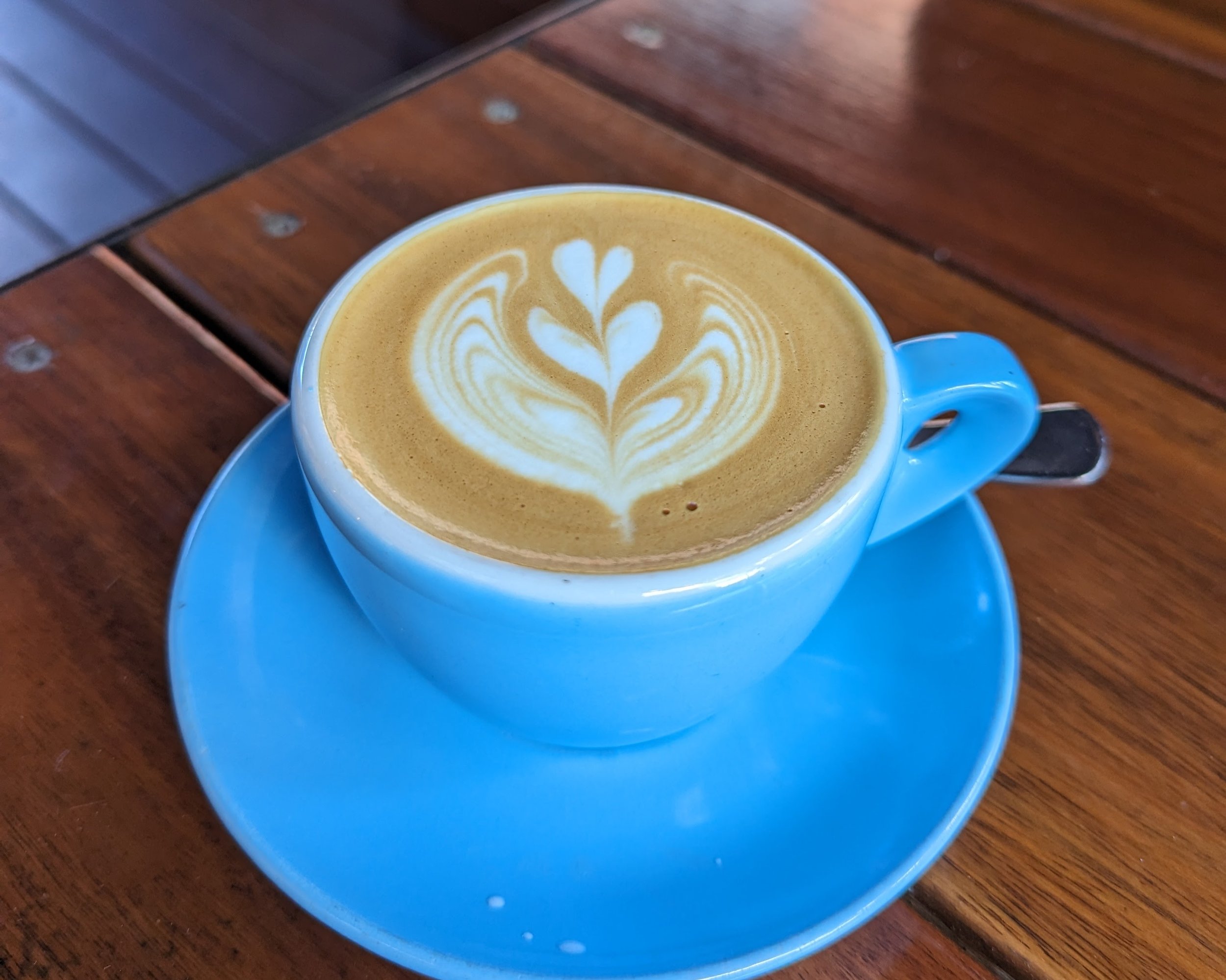 A flat white on a wooden table