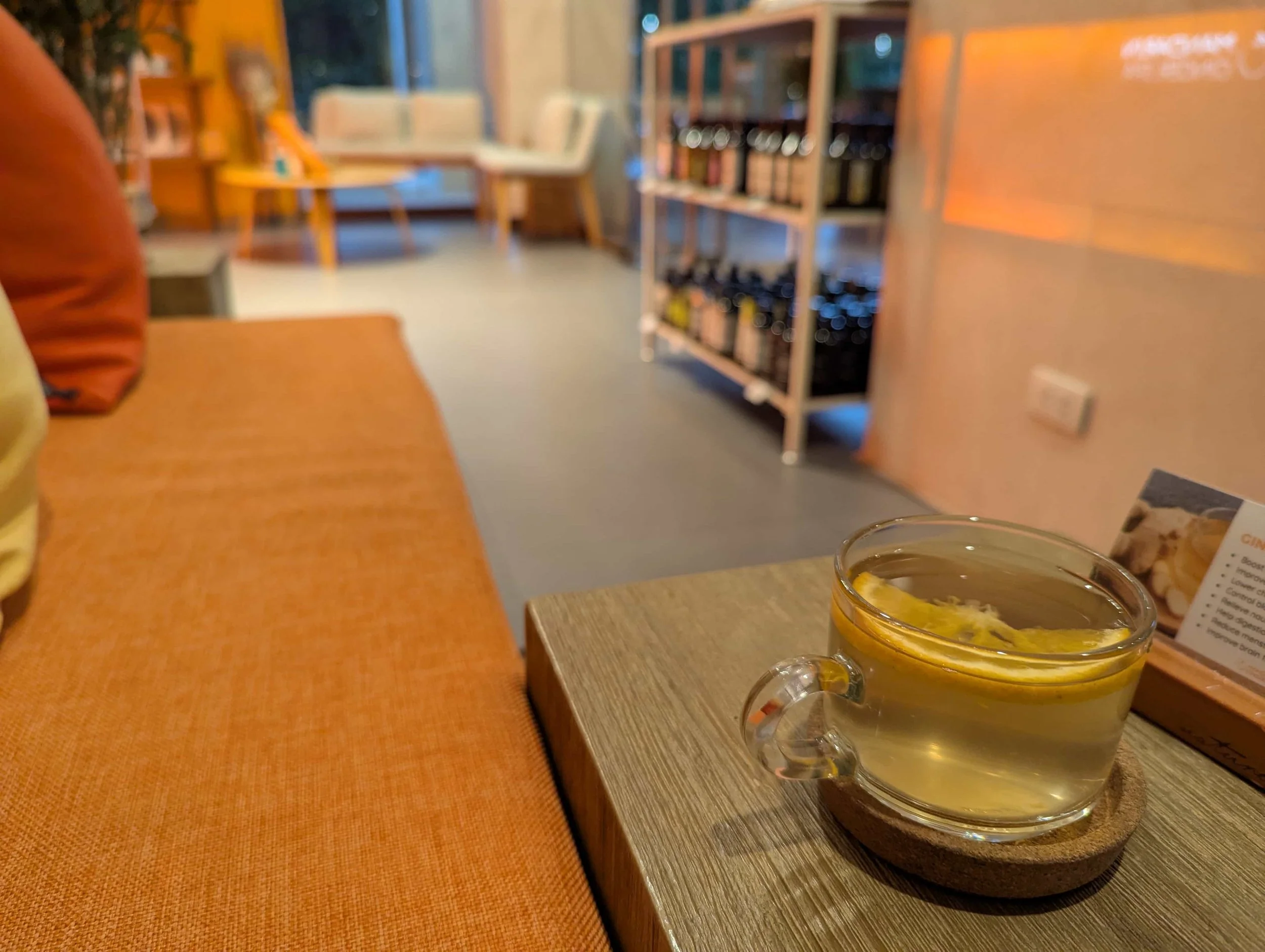 A tea on a table next to an orange couch at a massage place