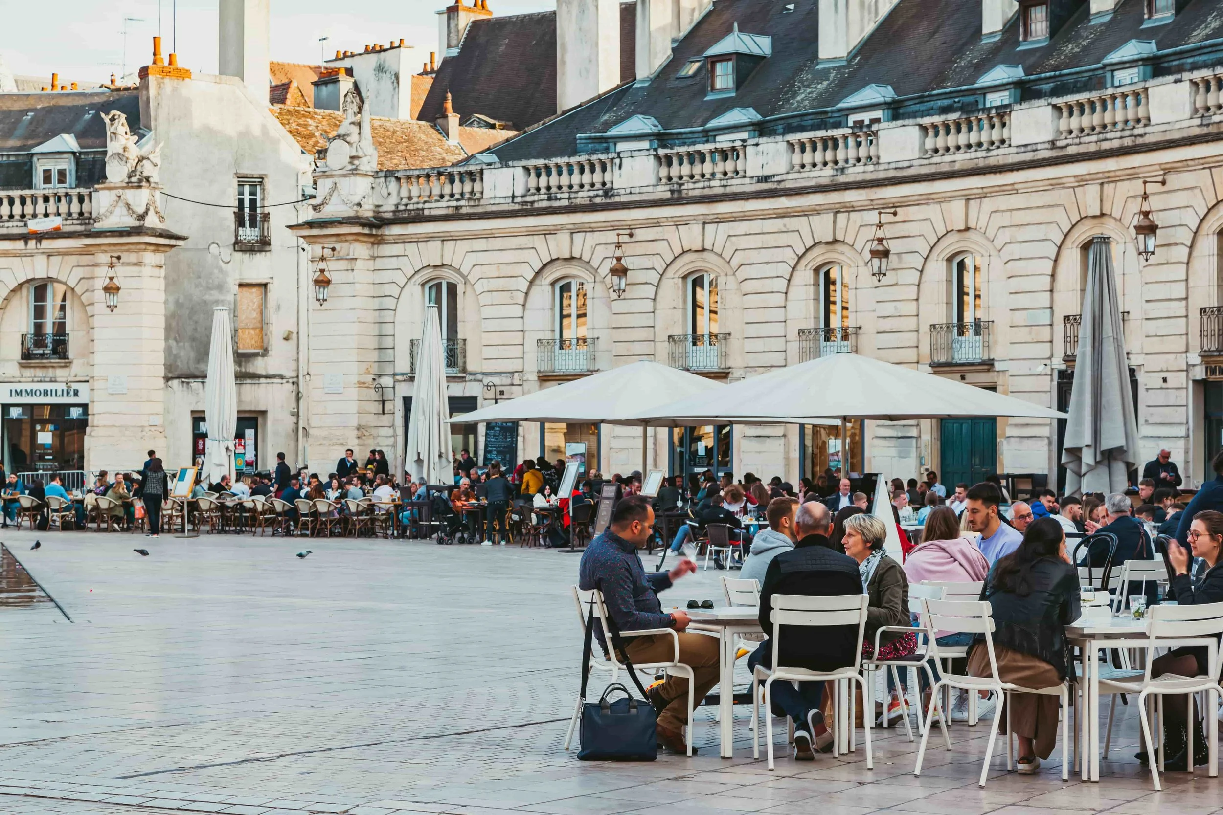 A European square with people sitting on terraces outside