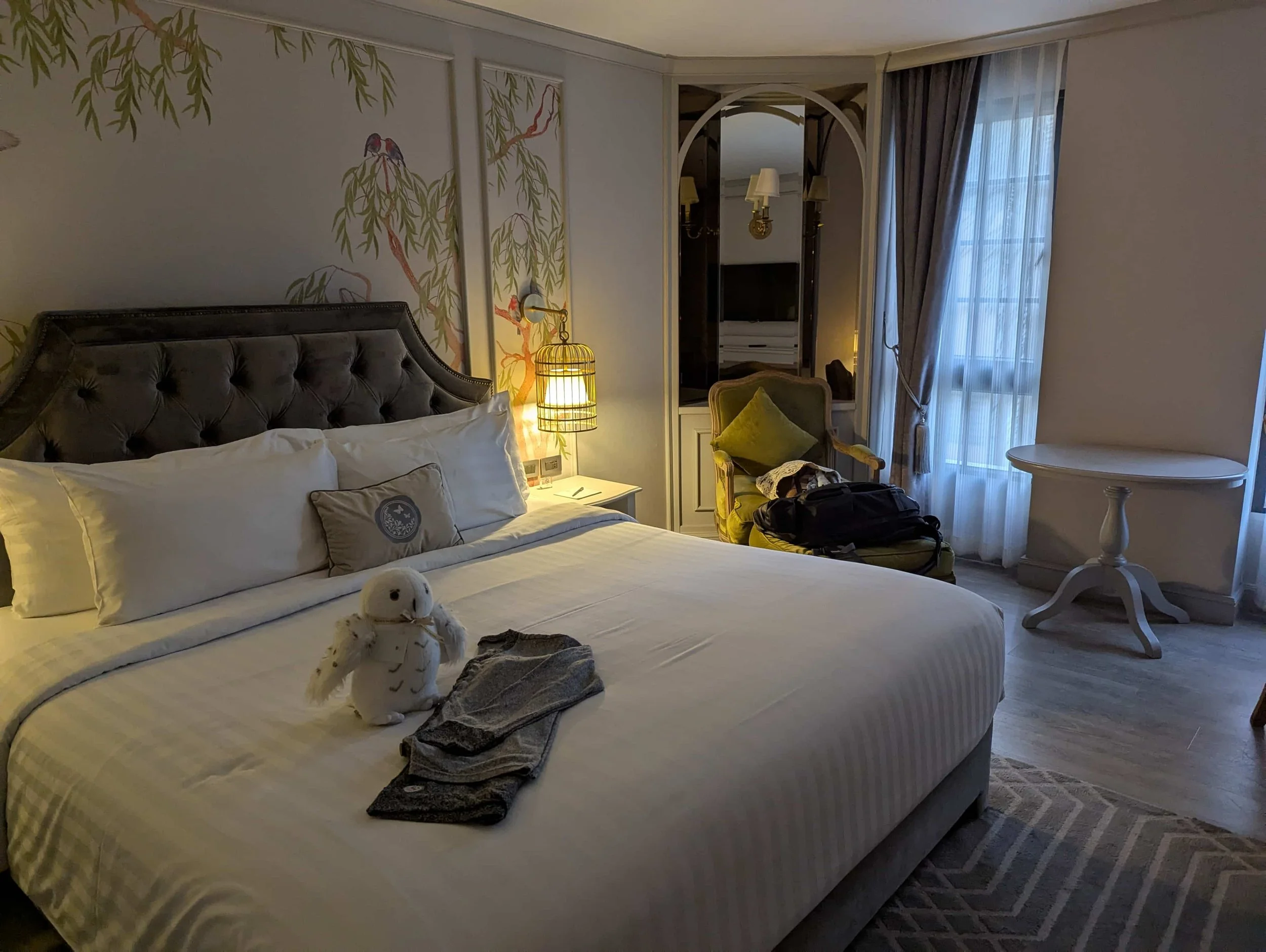 a hotel room with a bed and a plush owl on the bed