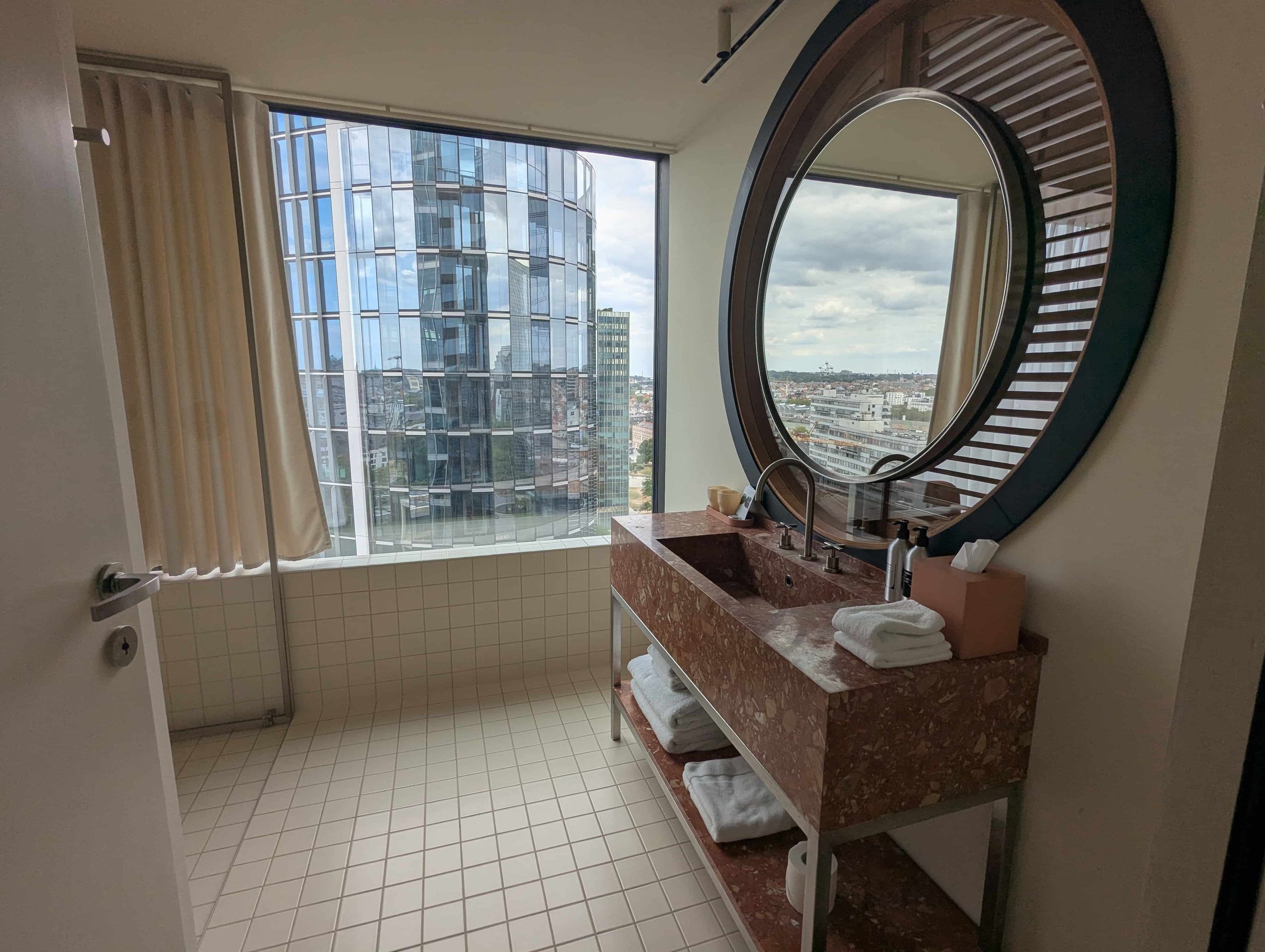 Hotel bathroom with sink and round mirror at the Standard Hotel in Brussels