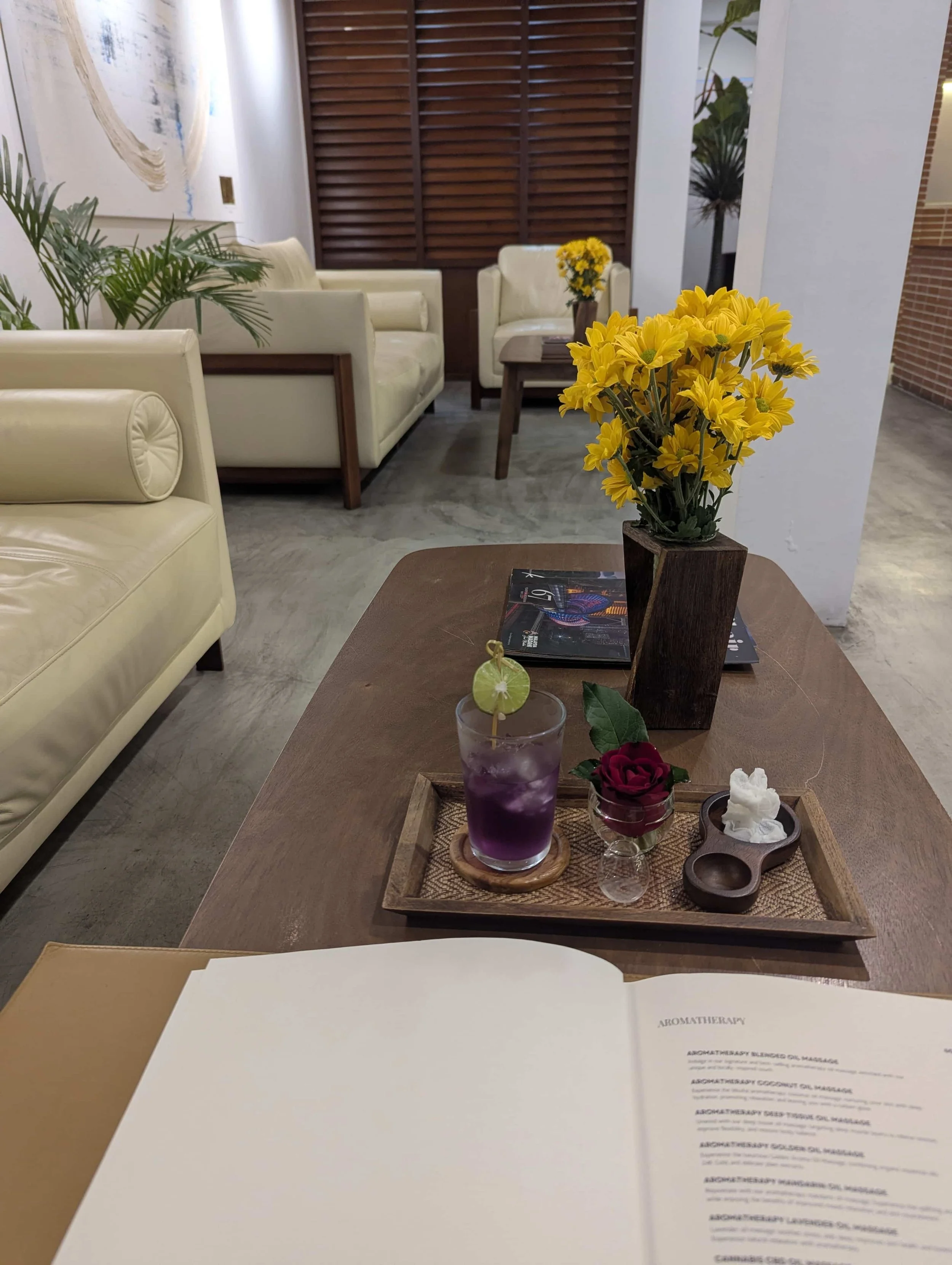 A spa lobby with sofas and an open spa menu