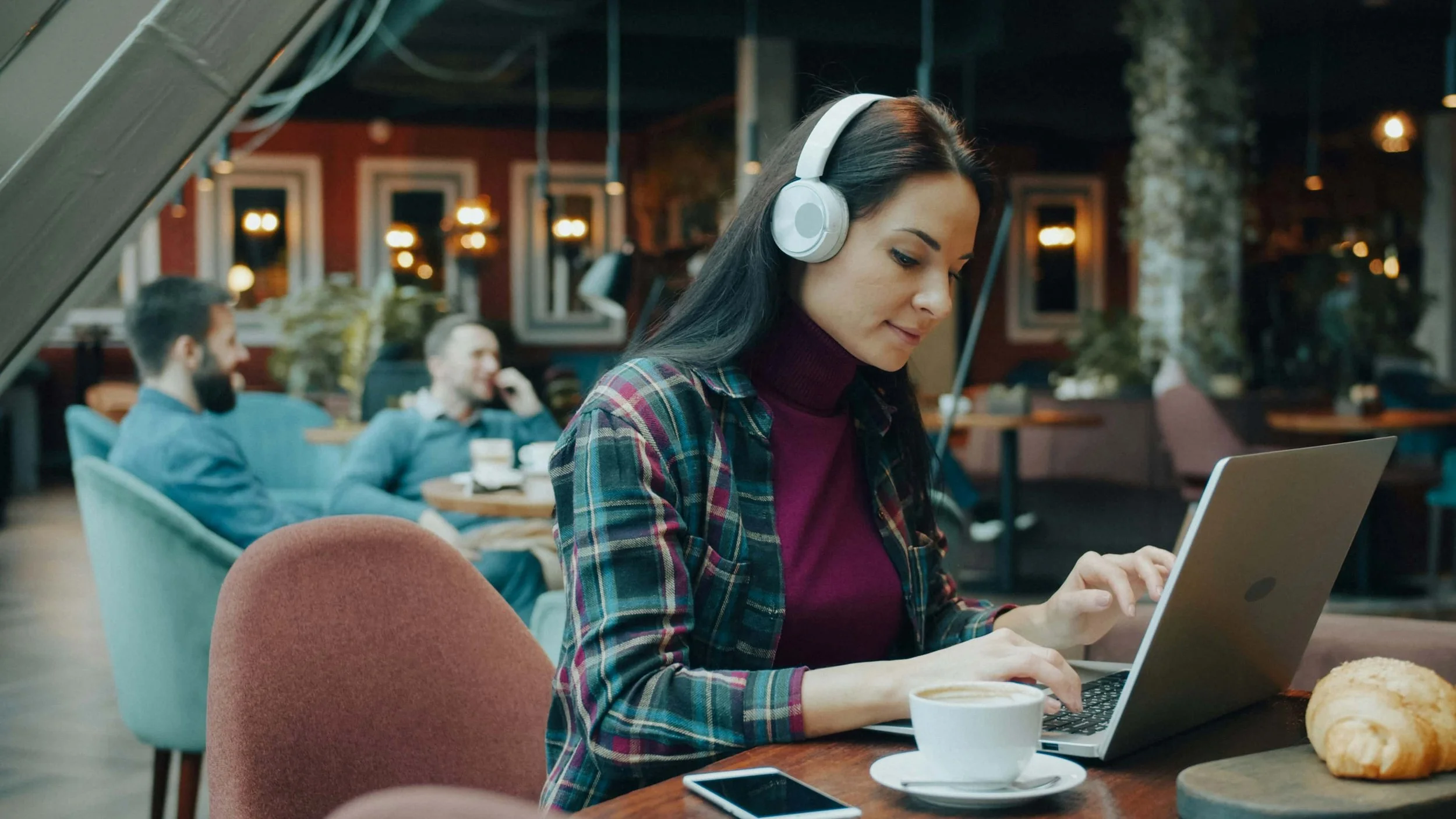 A woman working on her laptop in a cafe