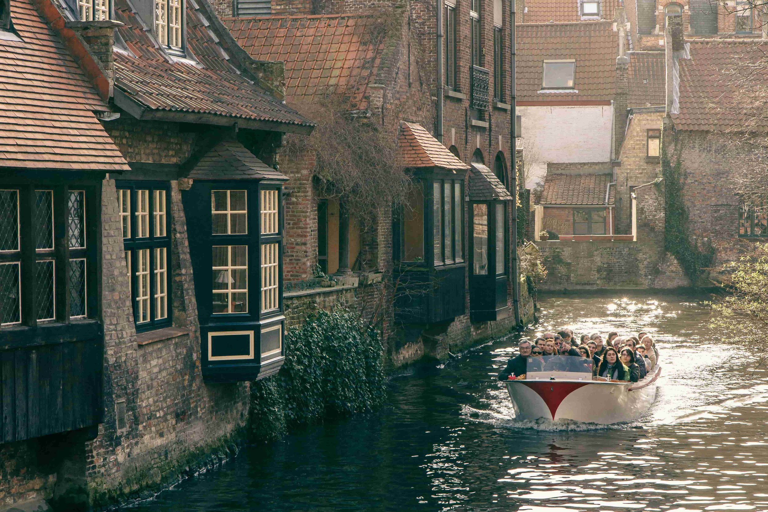 A boat on the canals in Bruges surrounded by houses