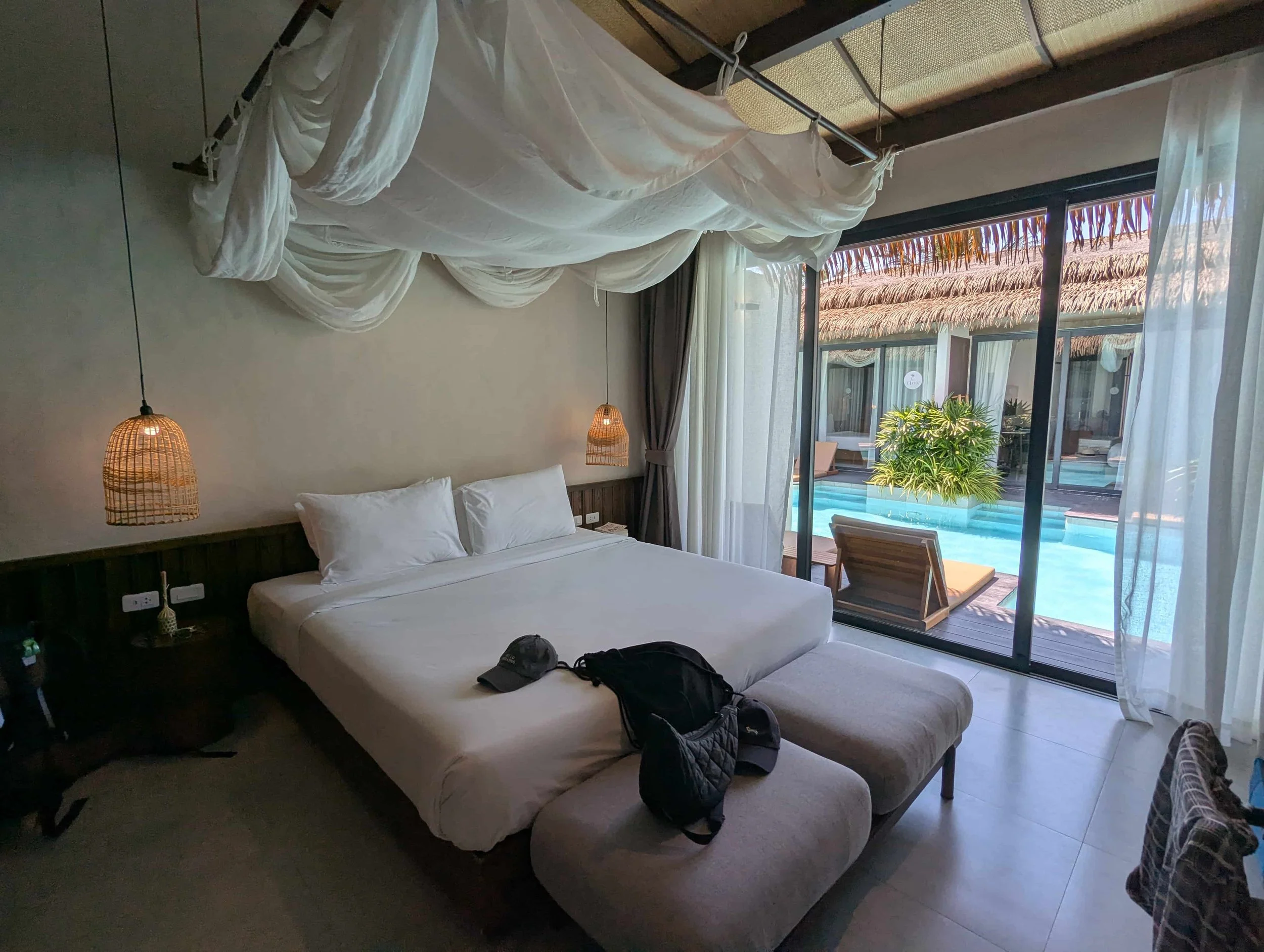 A hotel room with view on the bed and the pool outside