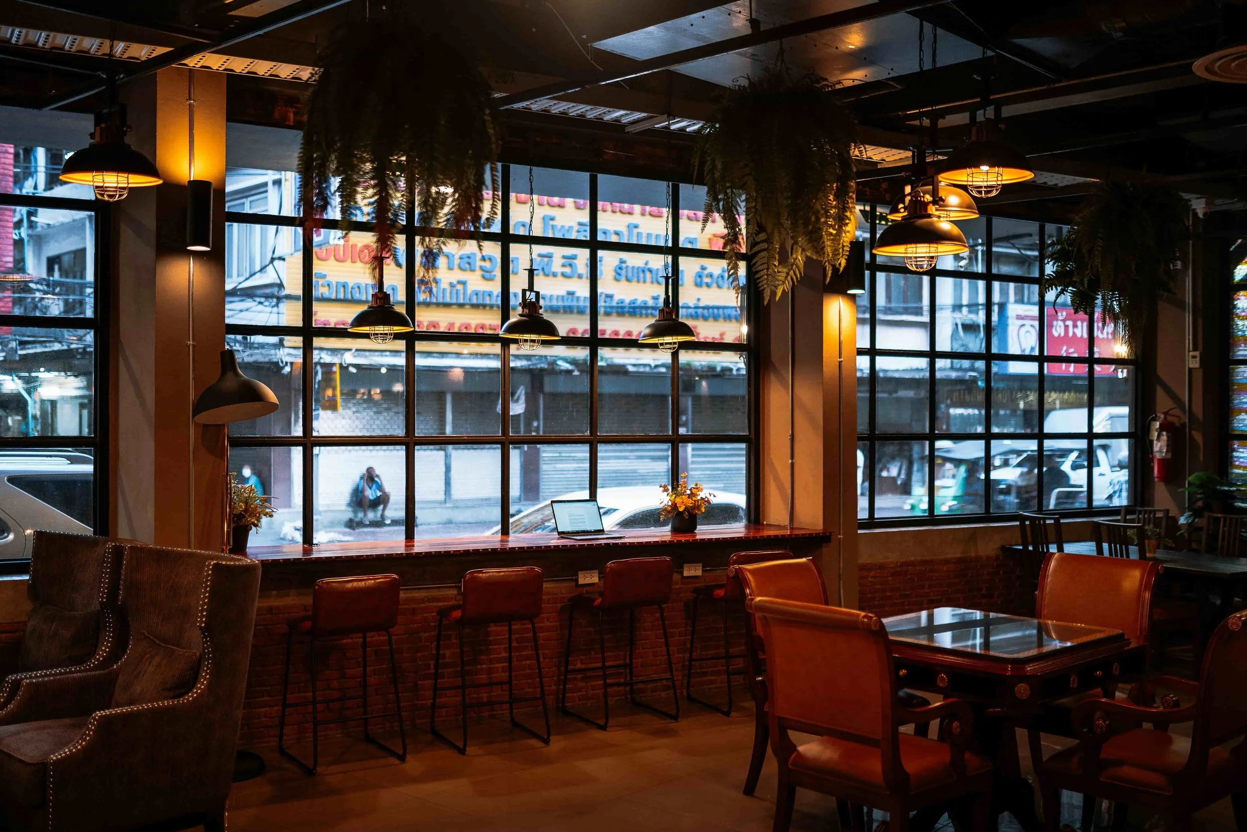 A cafe in Bangkok with tables and chairs overlooking a street