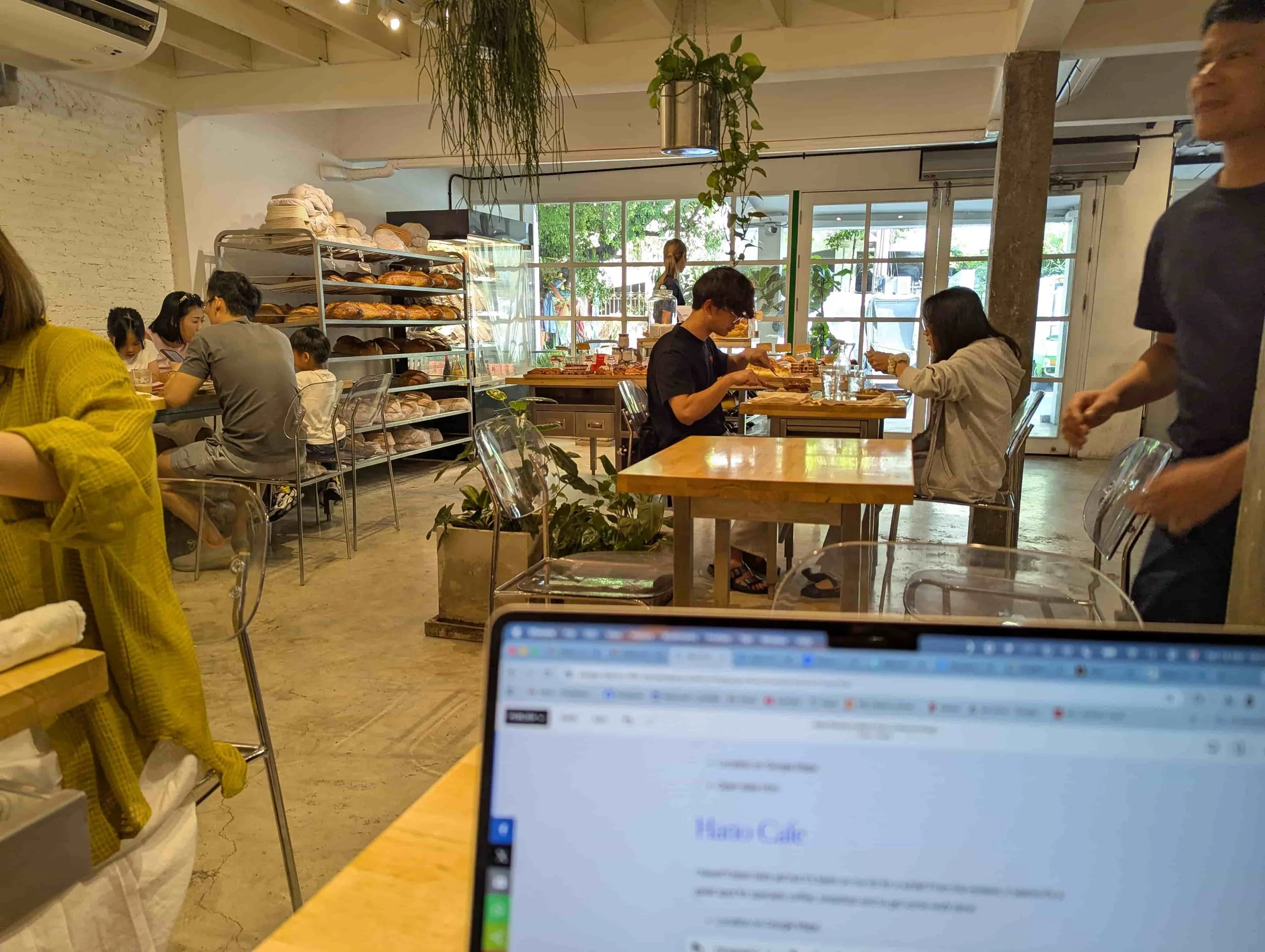 A laptop screen in a cafe and bakery with people sitting
