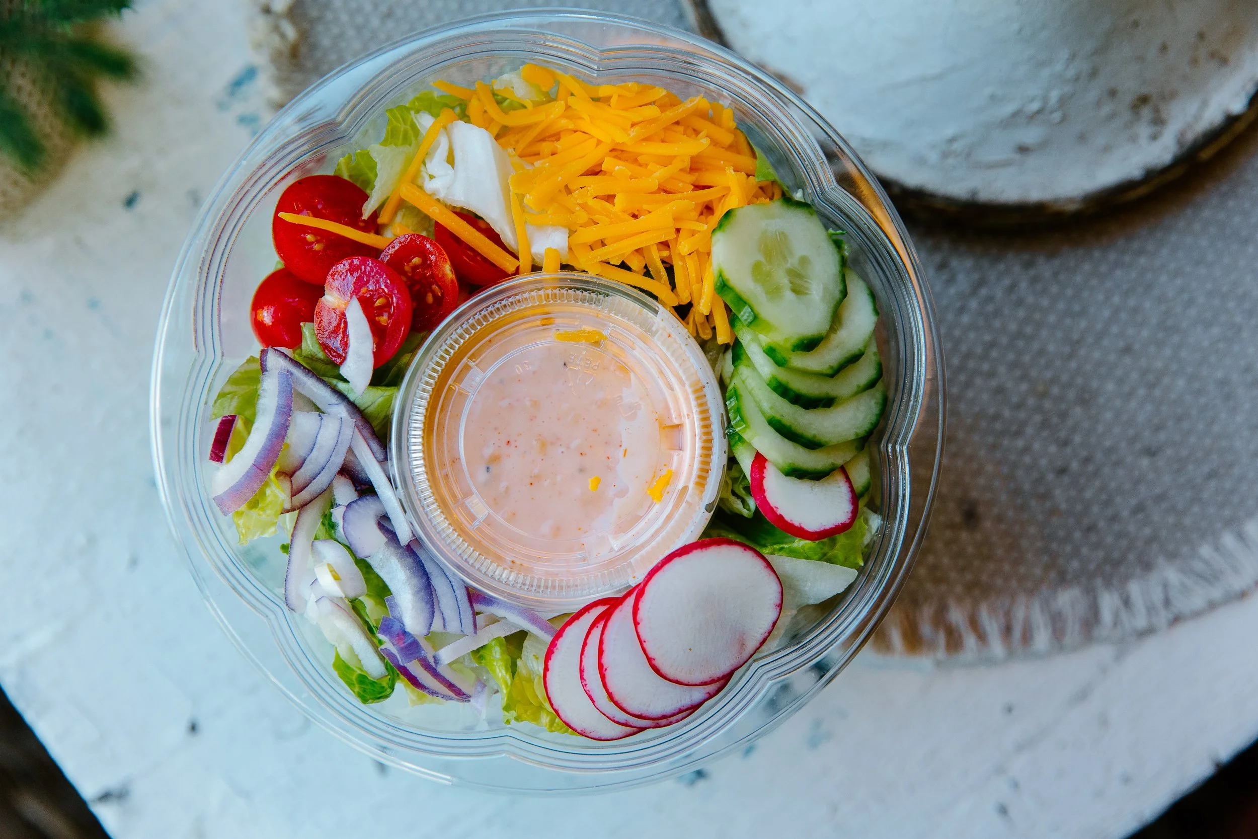 Easy Peasy Pantry tossed garden salad kit with tomatoes, cucumber, radishes, red onion, cheddar, and Thousand Island dressing.