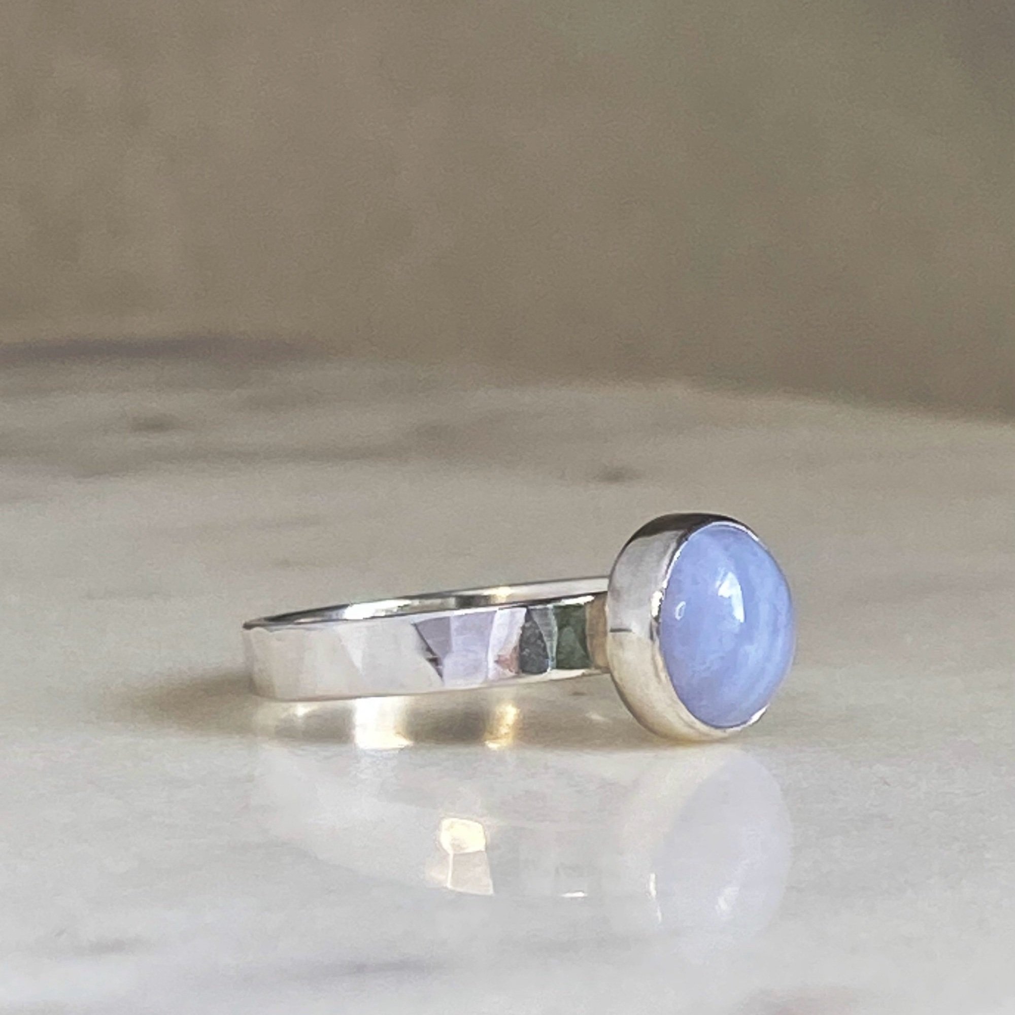 Walter and Nancy Jewellery's handmade, sterling silver and blue lace agate ring showing the side view highlighting the gently textured band.