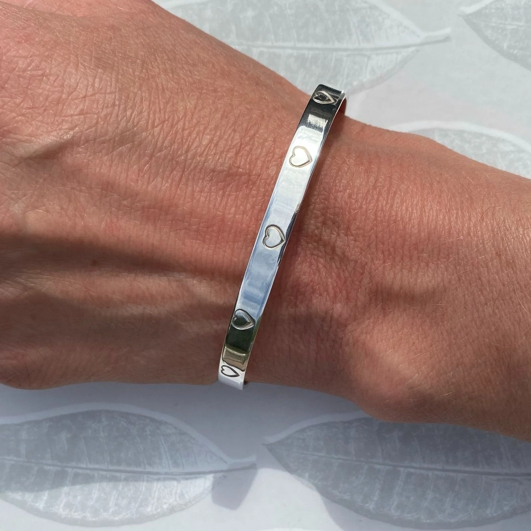 Sterling silver, hand made heart cuff bangle shown being worn..