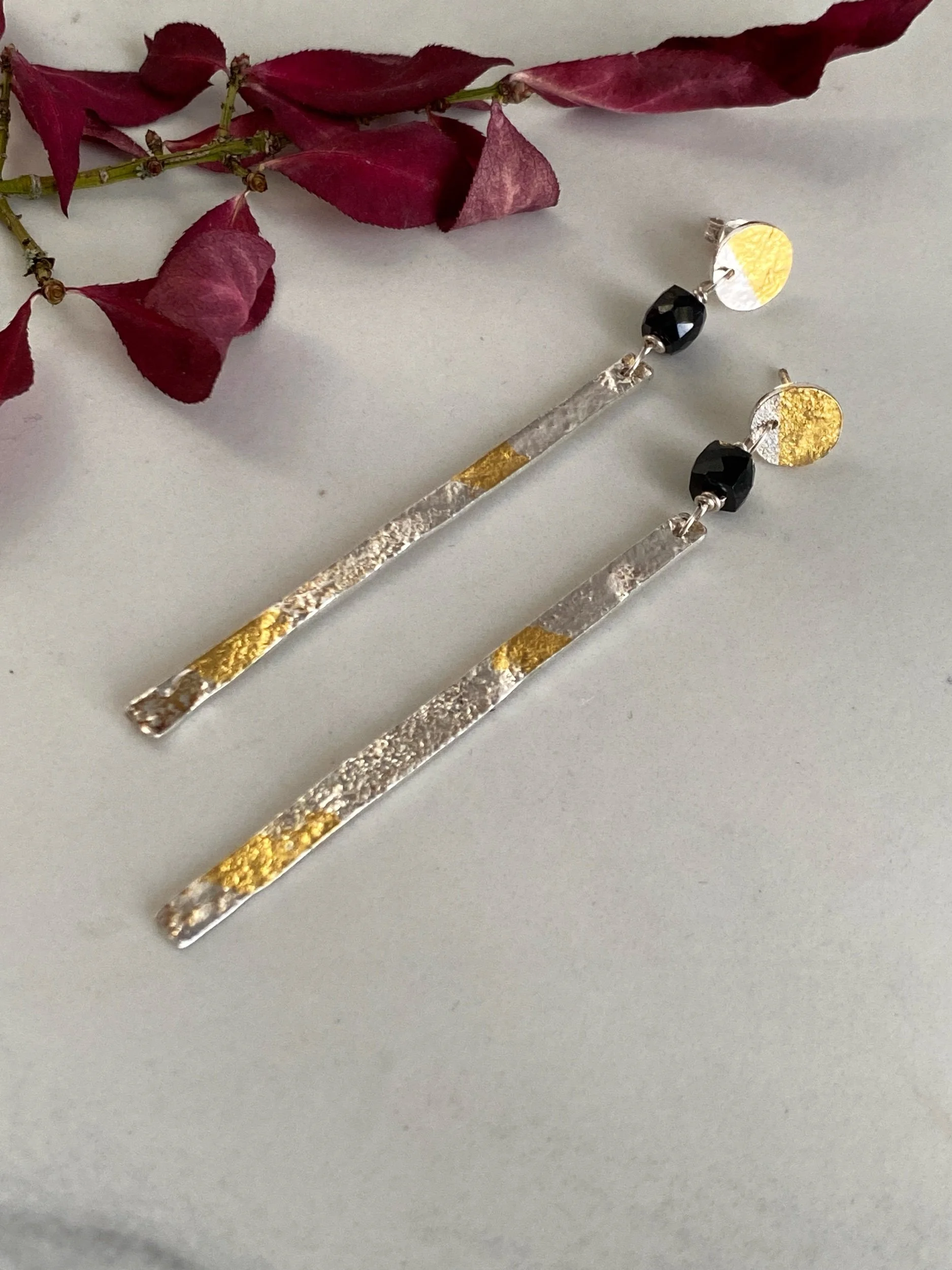 Handmade sterling silver and gold leaf earrings. They feature a black spinel bead to add extra sparkle.