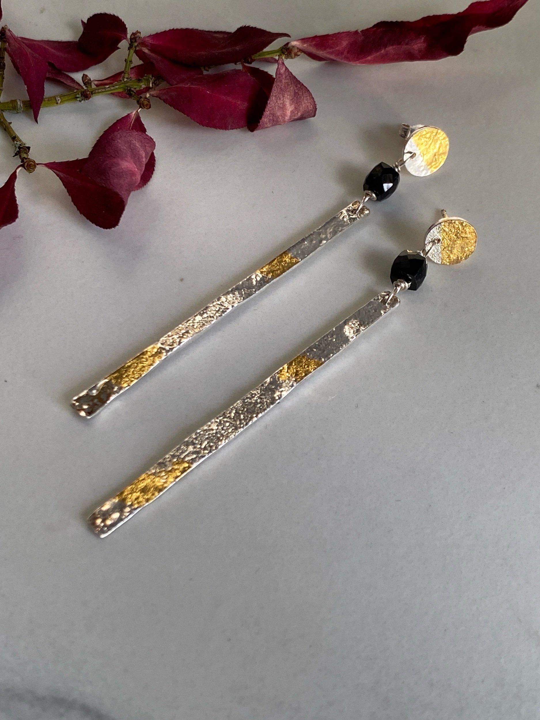 Handmade sterling silver and gold leaf earrings. They feature a black spinel bead to add extra sparkle.