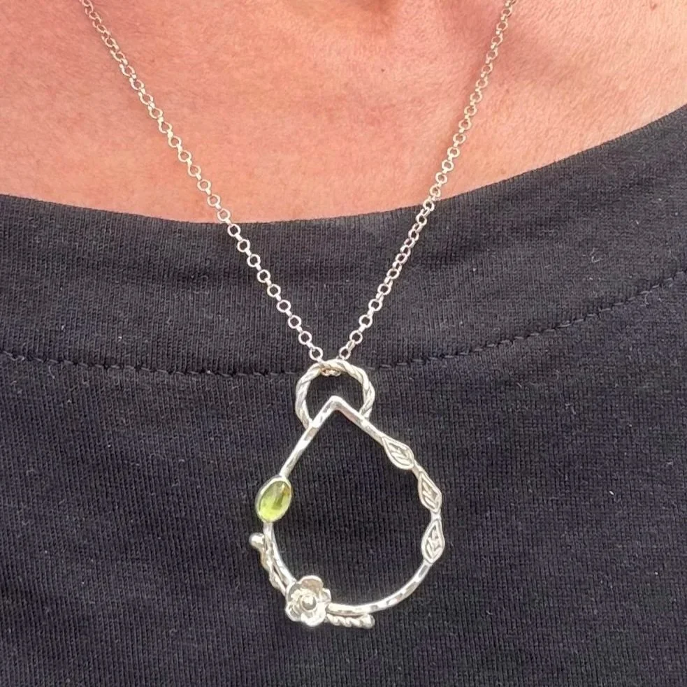 Handcrafted, botanical, sterling silver and peridot pendant. Handmade by Walter and Nancy Jewellery.