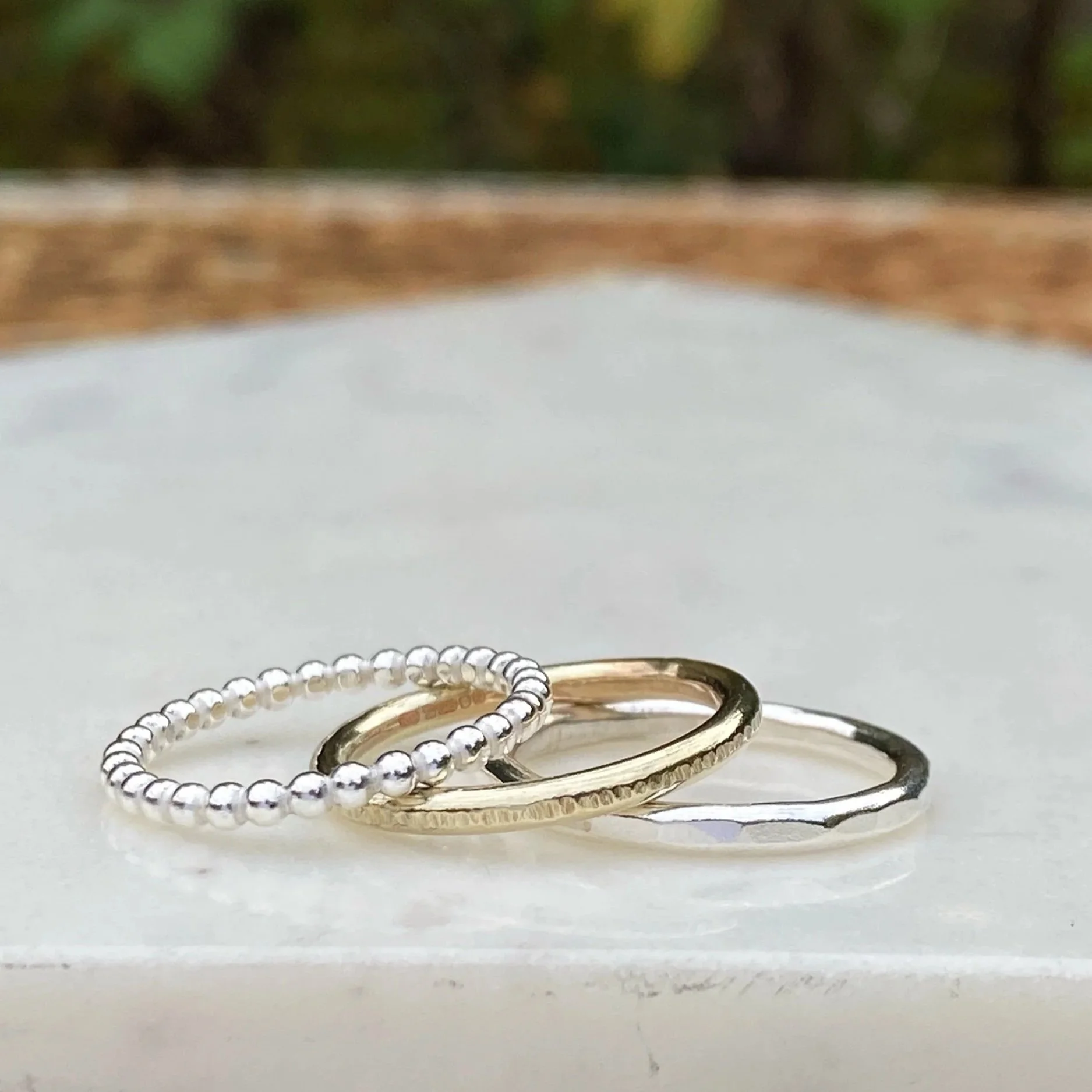 2mm wide 9ct Gold ring, handcrafted by Walter and Nancy Jewellery. Gently textured gold band handmade with love. Shown as part of a mixed metals stack.