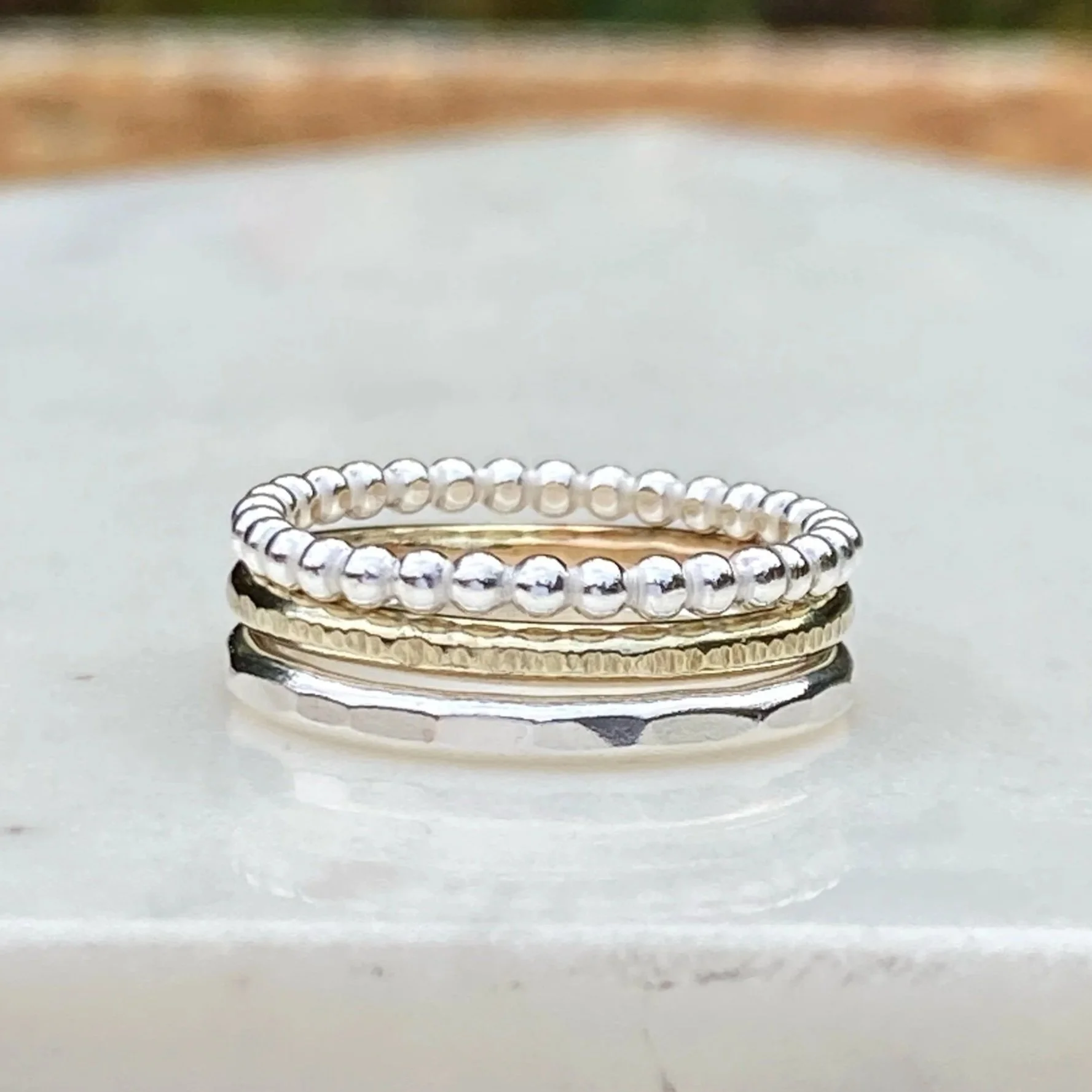 2mm wide 9ct Gold ring, handcrafted by Walter and Nancy Jewellery. Gently textured gold band handmade with love. Shown as part of a mixed metals stack.