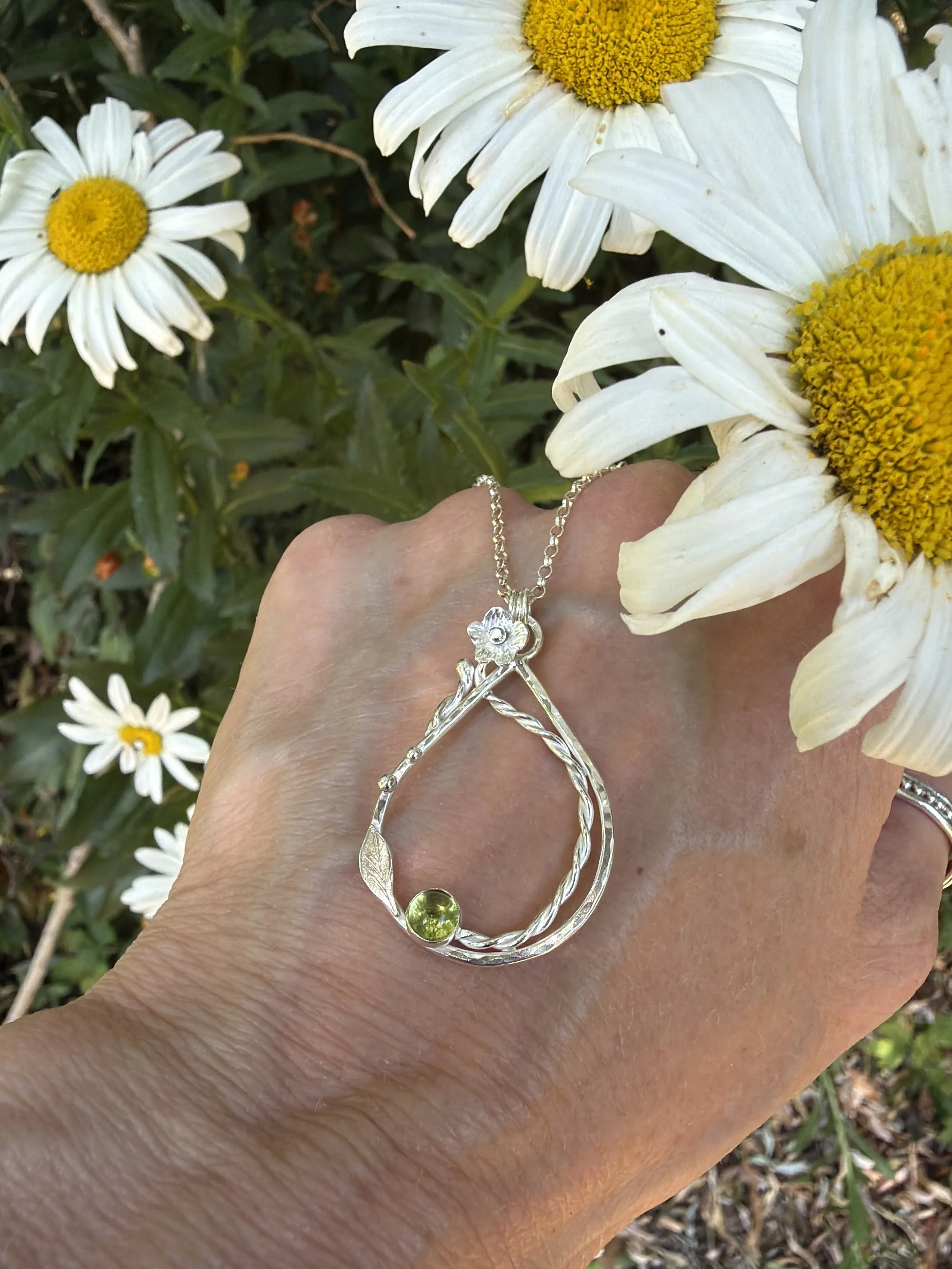 Handcrafted, botanical, sterling silver and peridot pendant. Handmade by Walter and Nancy Jewellery.