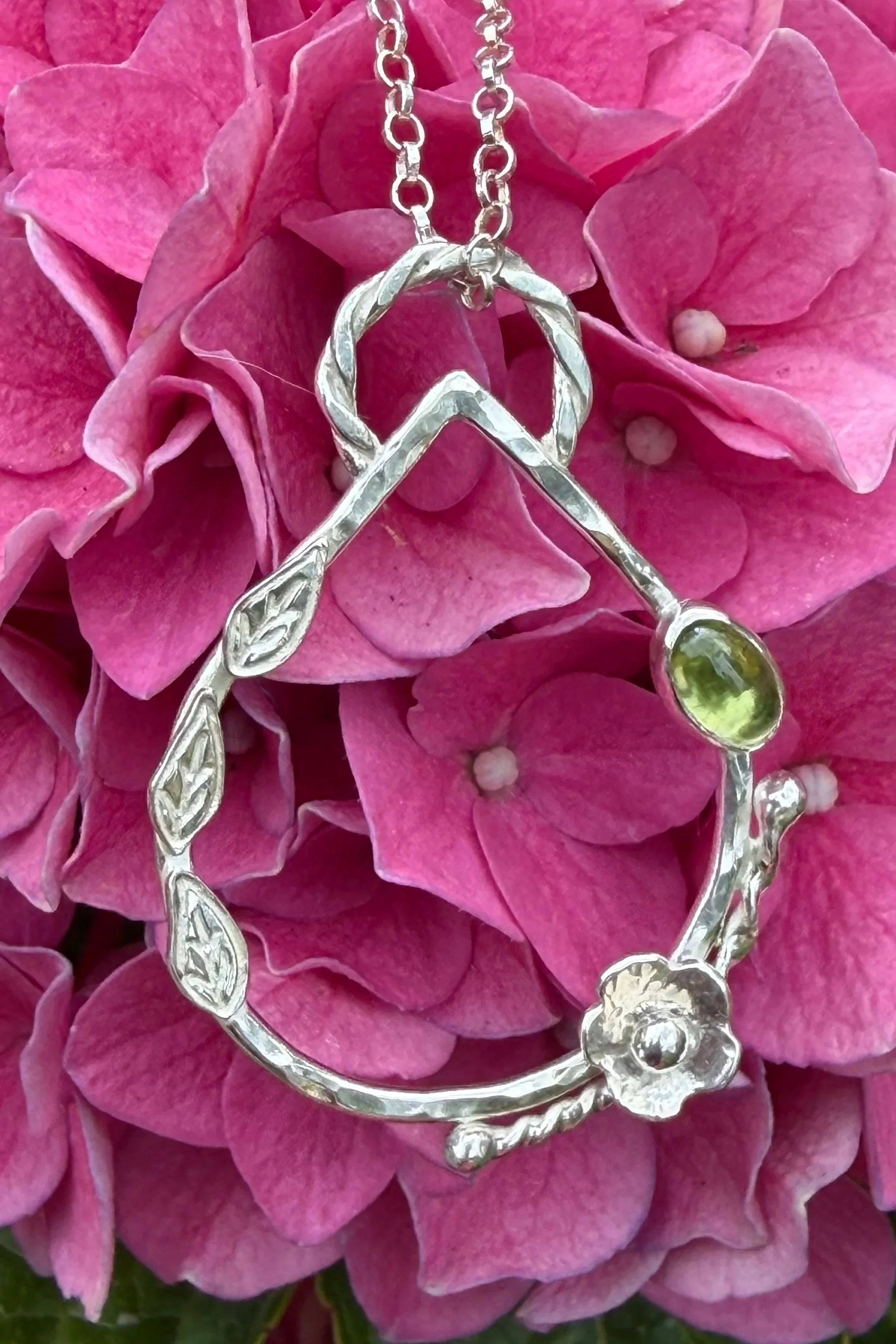 Handcrafted, botanical, sterling silver and peridot pendant. Handmade by Walter and Nancy Jewellery.