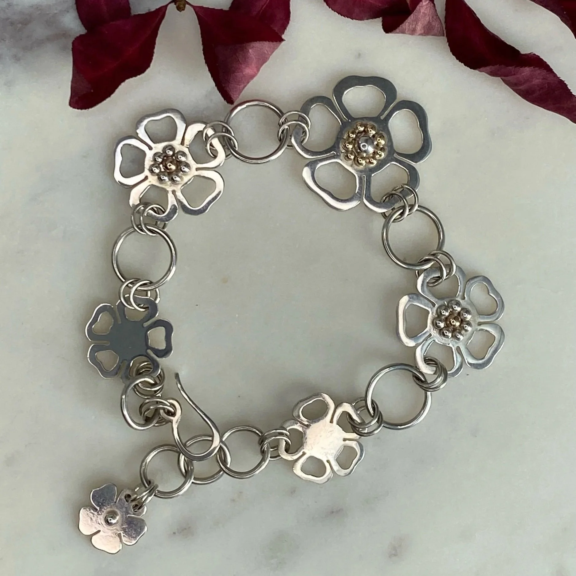 One of a kind, handmade sterling silver and nine carat gold flower bracelet. Made by Walter and Nancy Jewellery.