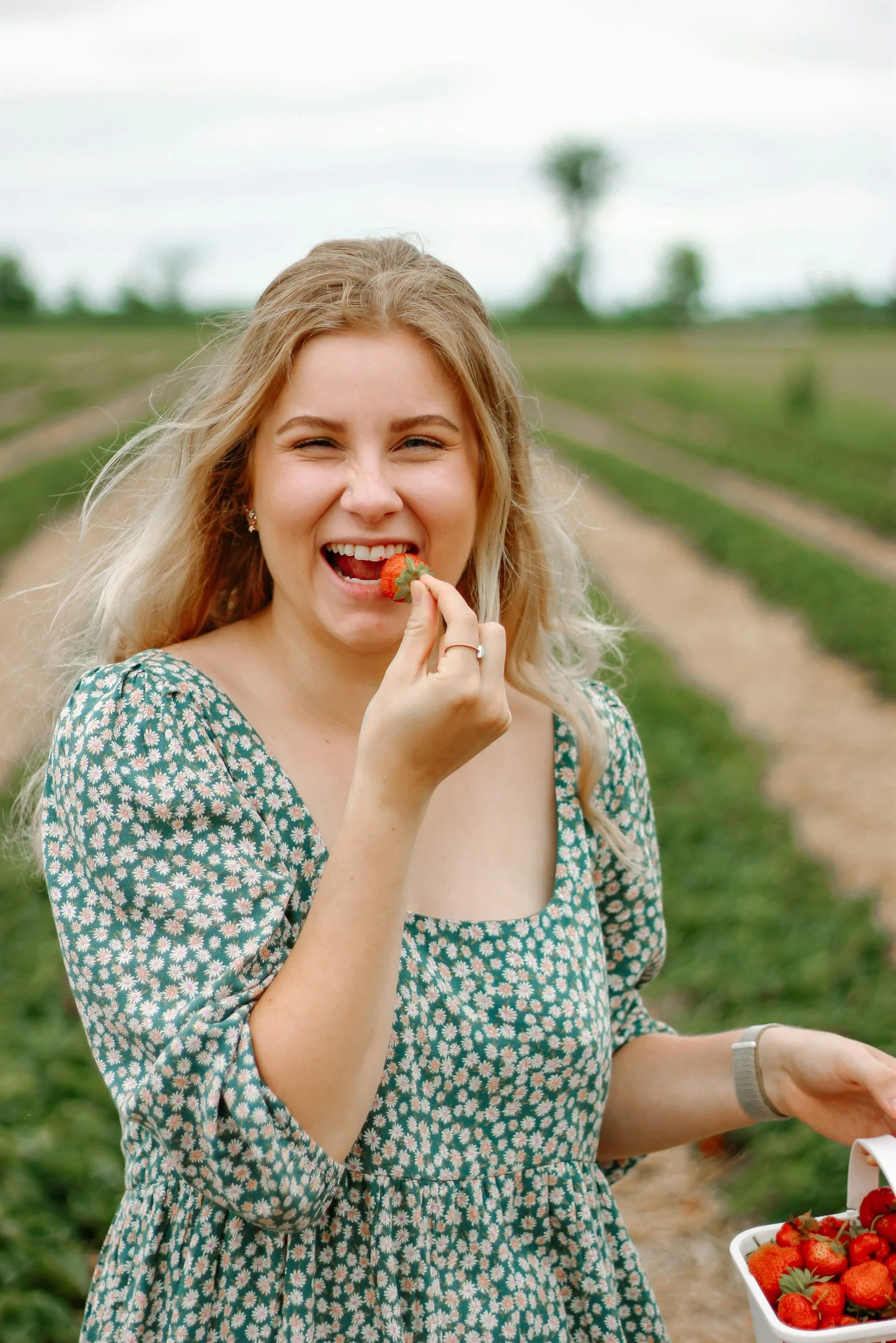 A woman happily eating a strawberry from an Ohio farm