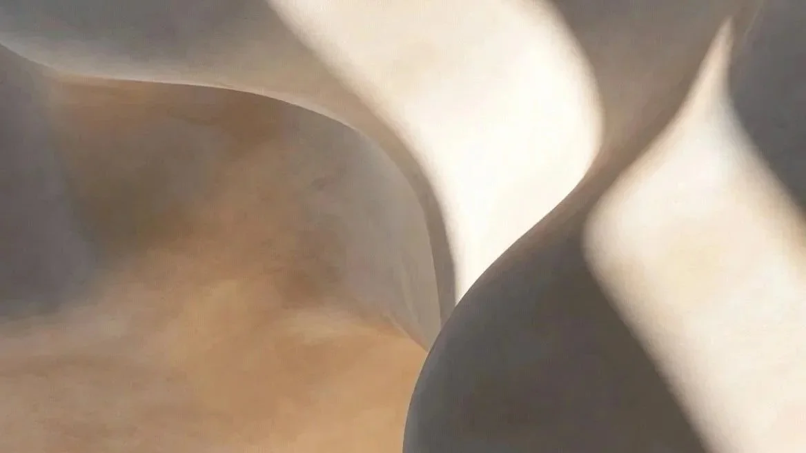 Close-up of crumpled white and beige paper or material with soft shadows and curves.