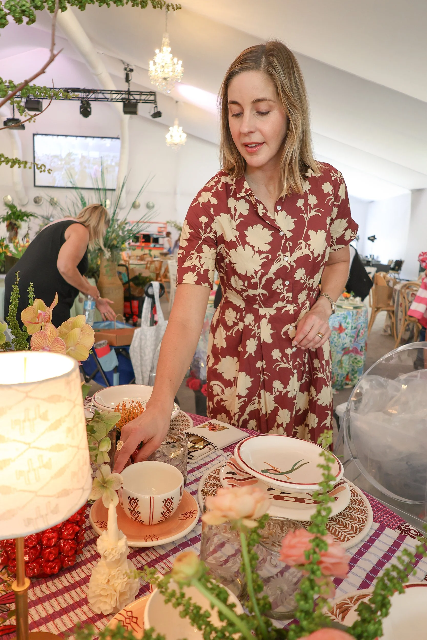 Regan Billingsley arranges handmade tableware and flowers for the Naples Tables event.