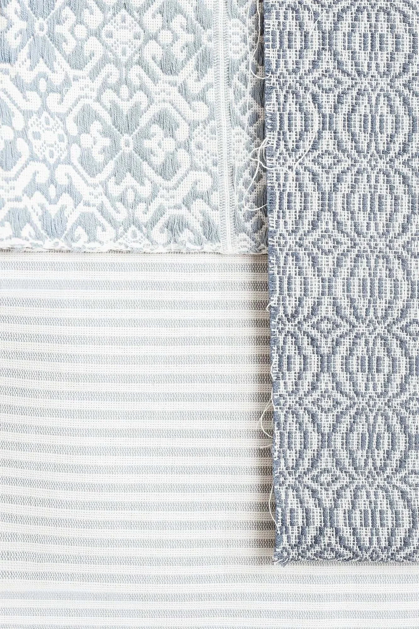Close-up of layered blue-and-white RB Curated textile samples showing woven, striped, and patterned textures.
