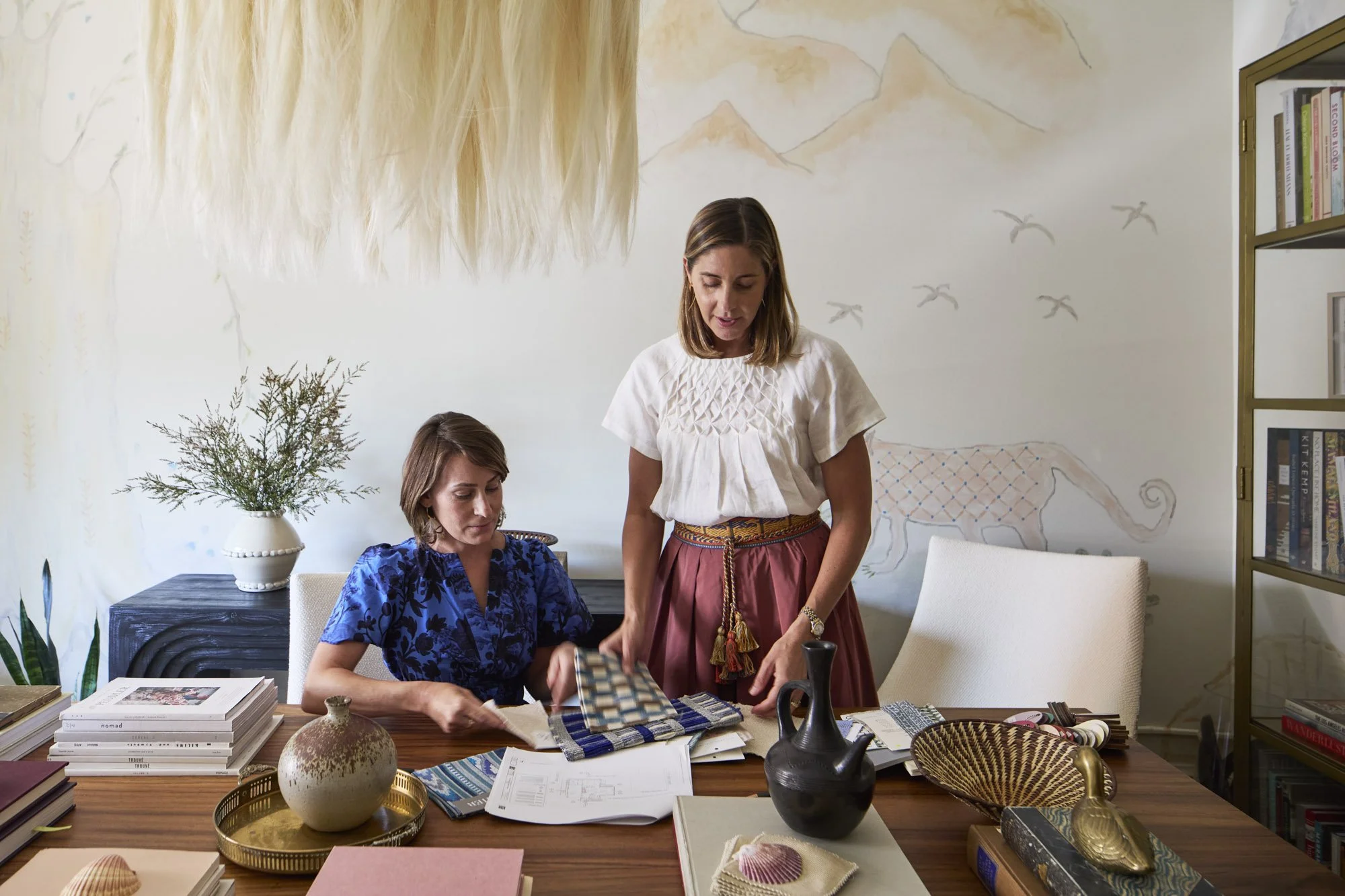 Regan and her assistant review colorful textile samples in the Regan Billingsley Interiors studio.