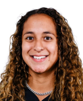 A young woman with curly hair smiling at the camera.