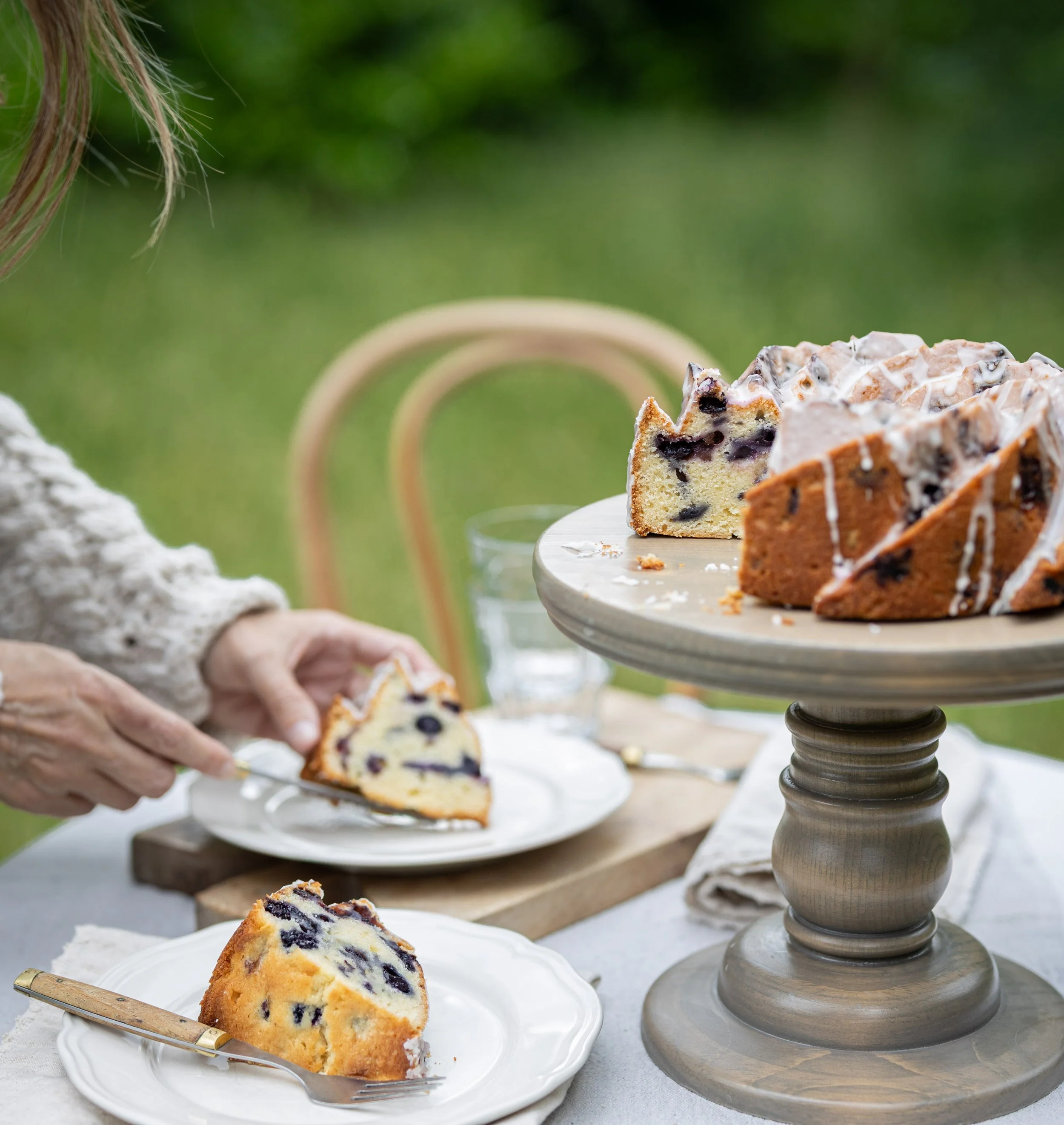 Lemon blueberry Bundt cake on a cake stand with lemon glaze