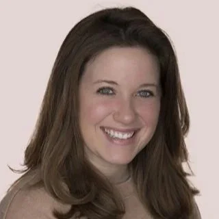 a smiling woman with a bright white smile and a tan shirt