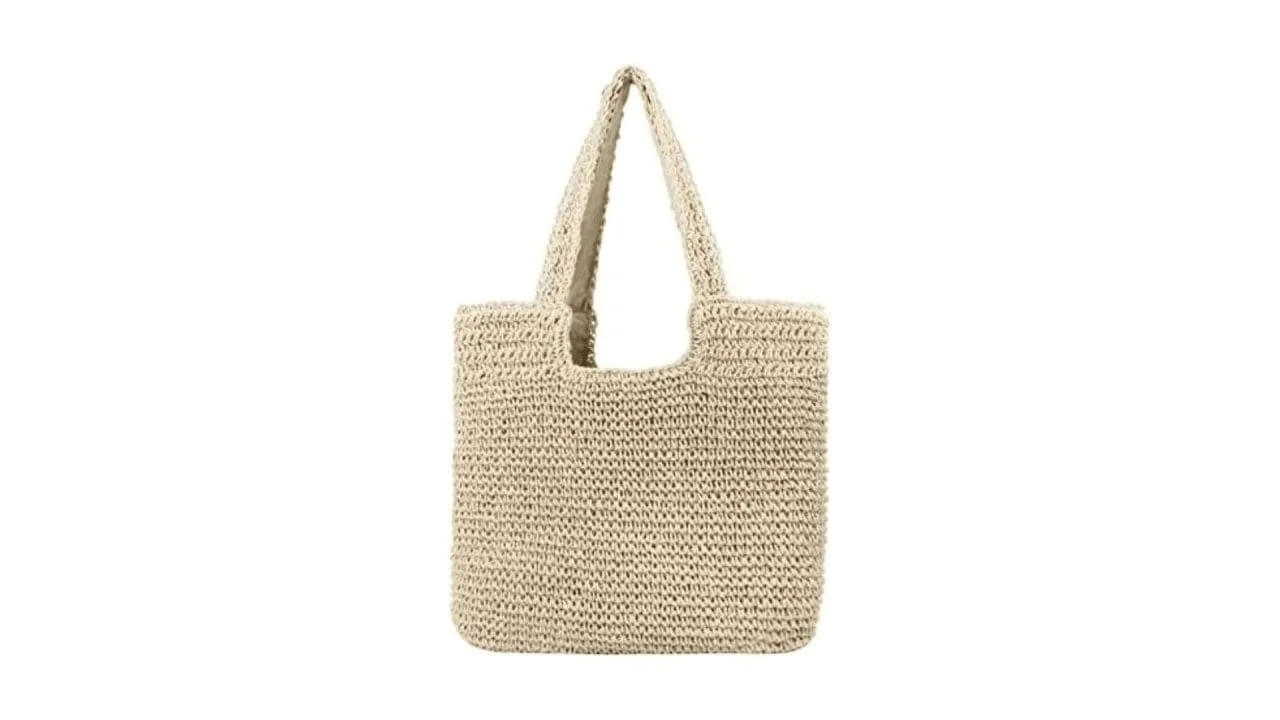 Beige crochet tote bag with two handles on a white background.