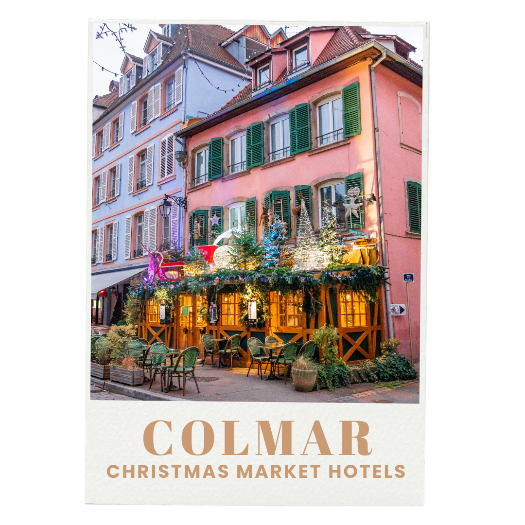 Decorated building with Christmas lights and decorations, with outdoor seating and a sign that says 'Colmar Christmas Market Hotels'.