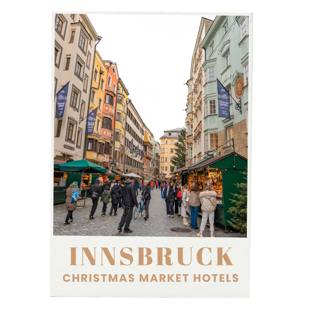 Street scene in Innsbruck during Christmas market with people shopping at stalls, colorful historic buildings, and Christmas decorations.