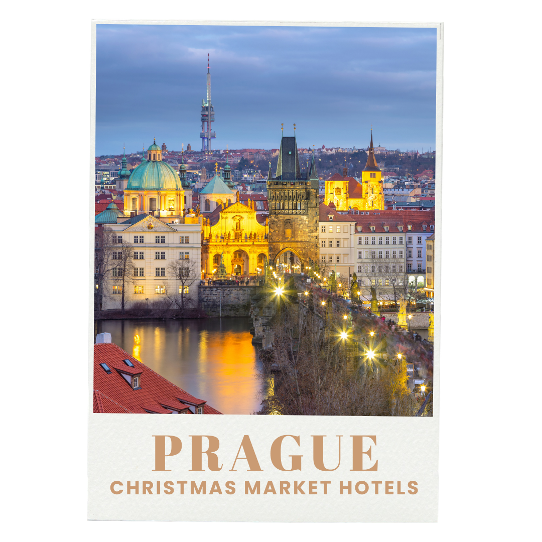 A cityscape of Prague at dusk with illuminated historical buildings and the Vltava River in the foreground.