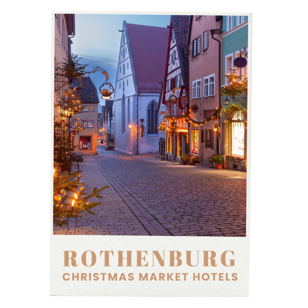 A cobblestone street decorated with Christmas lights and ornaments in Rothenburg, Germany, with traditional European buildings and a church in the background at dusk.