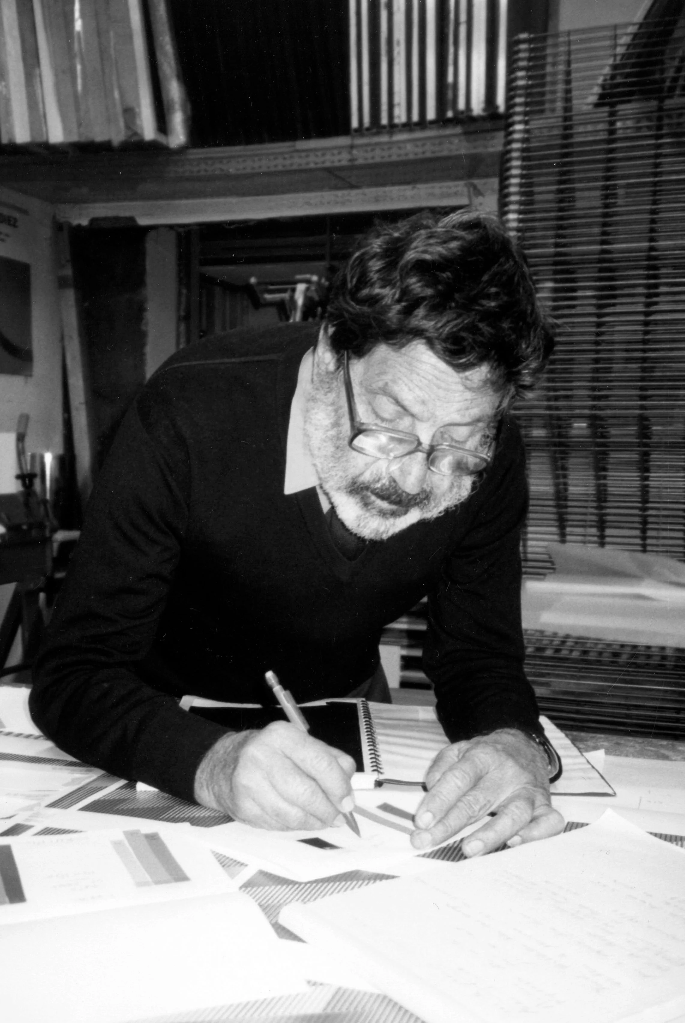 Black and white photo of artist Carlos Cruz-Diez writing