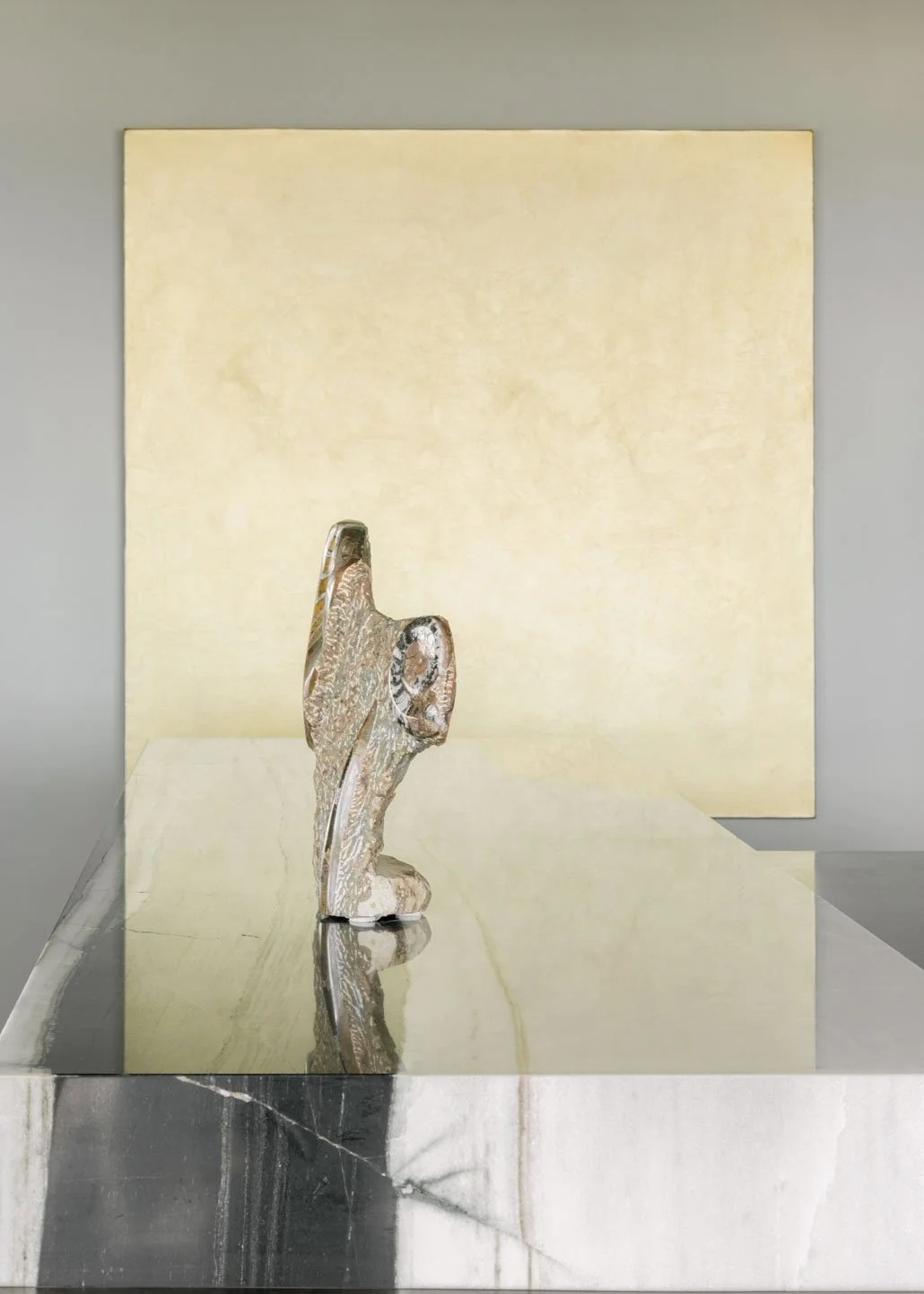 Contemporary abstract sculpture on a marble kitchen island with a gold art piece in a luxury Brutalist penthouse