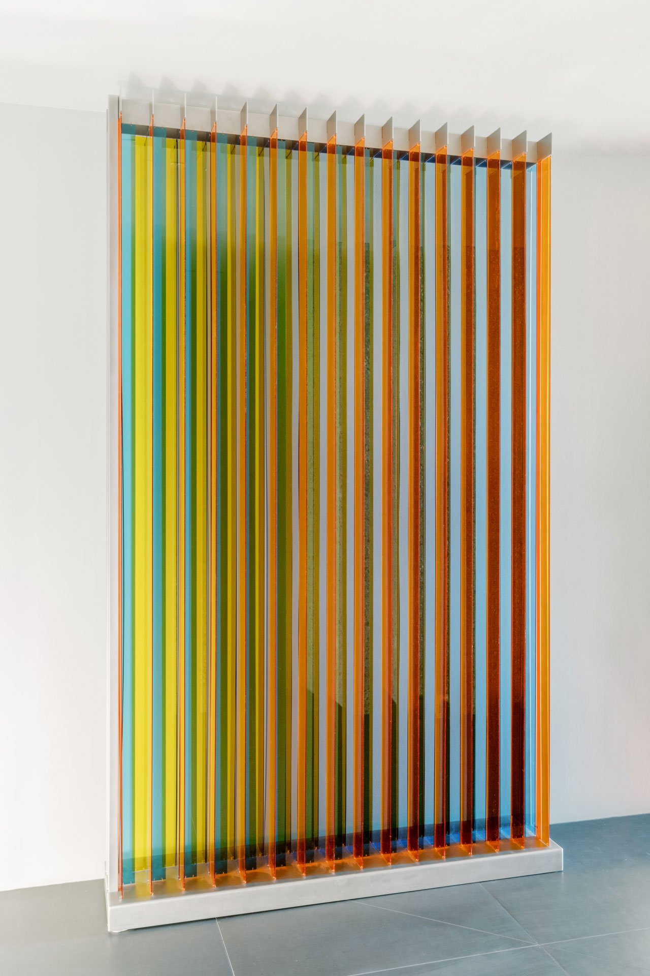 Colorful vertical glass panels with orange borders in an art installation.