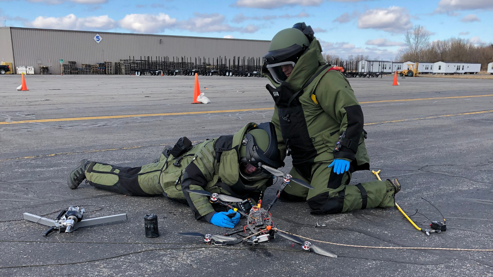Explosive Ordnance Disposal Technicians examine a weaponized drone during a training exercise.