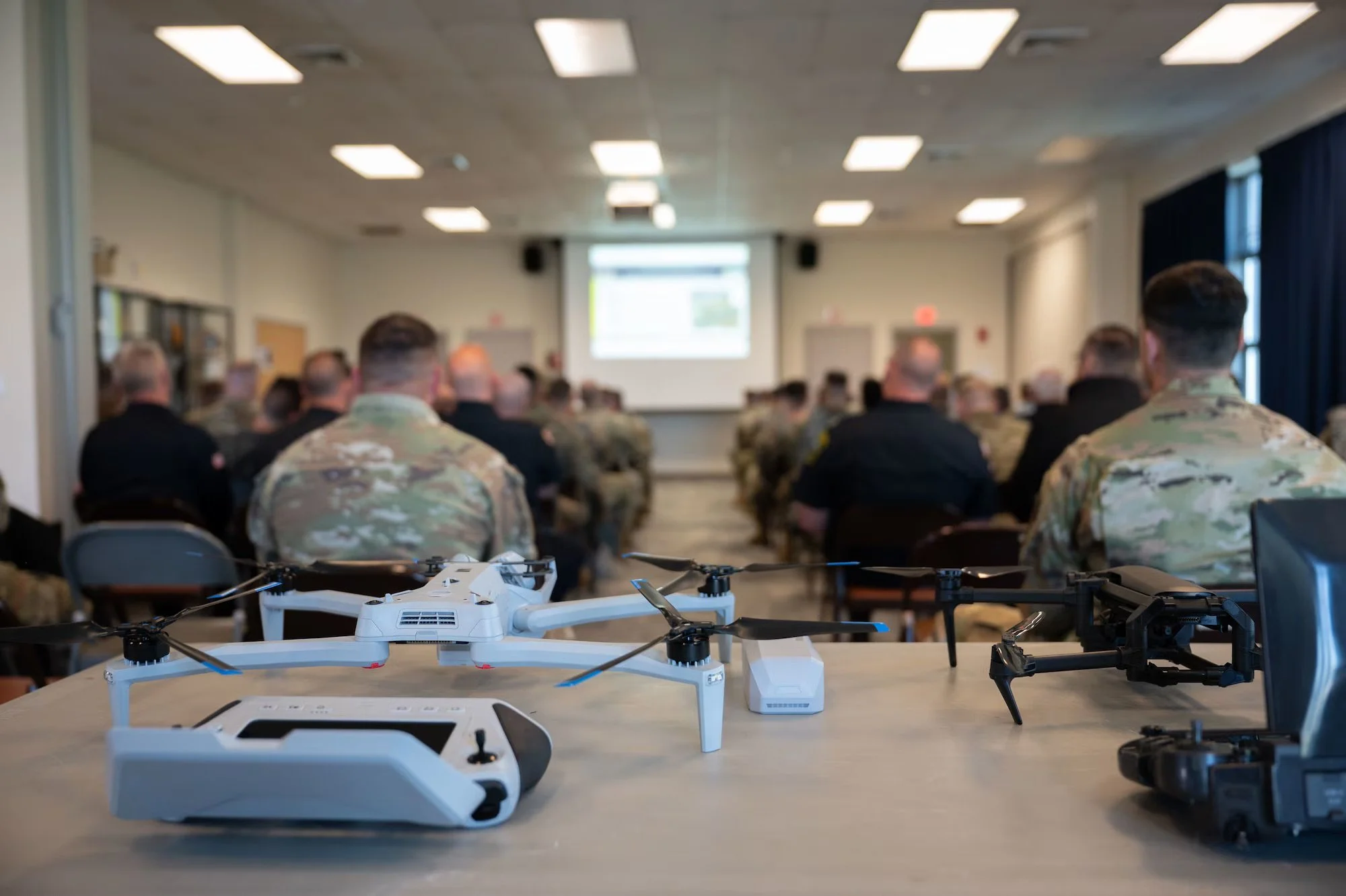 Students examining inert drone ordnance training aids during UAS hazard training