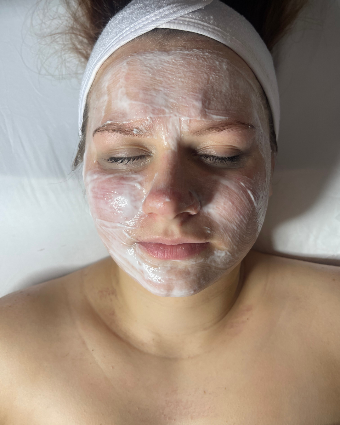 A relaxing facial treatment with a hydrating mask applied to the face at Remedy Salon & Wellness.