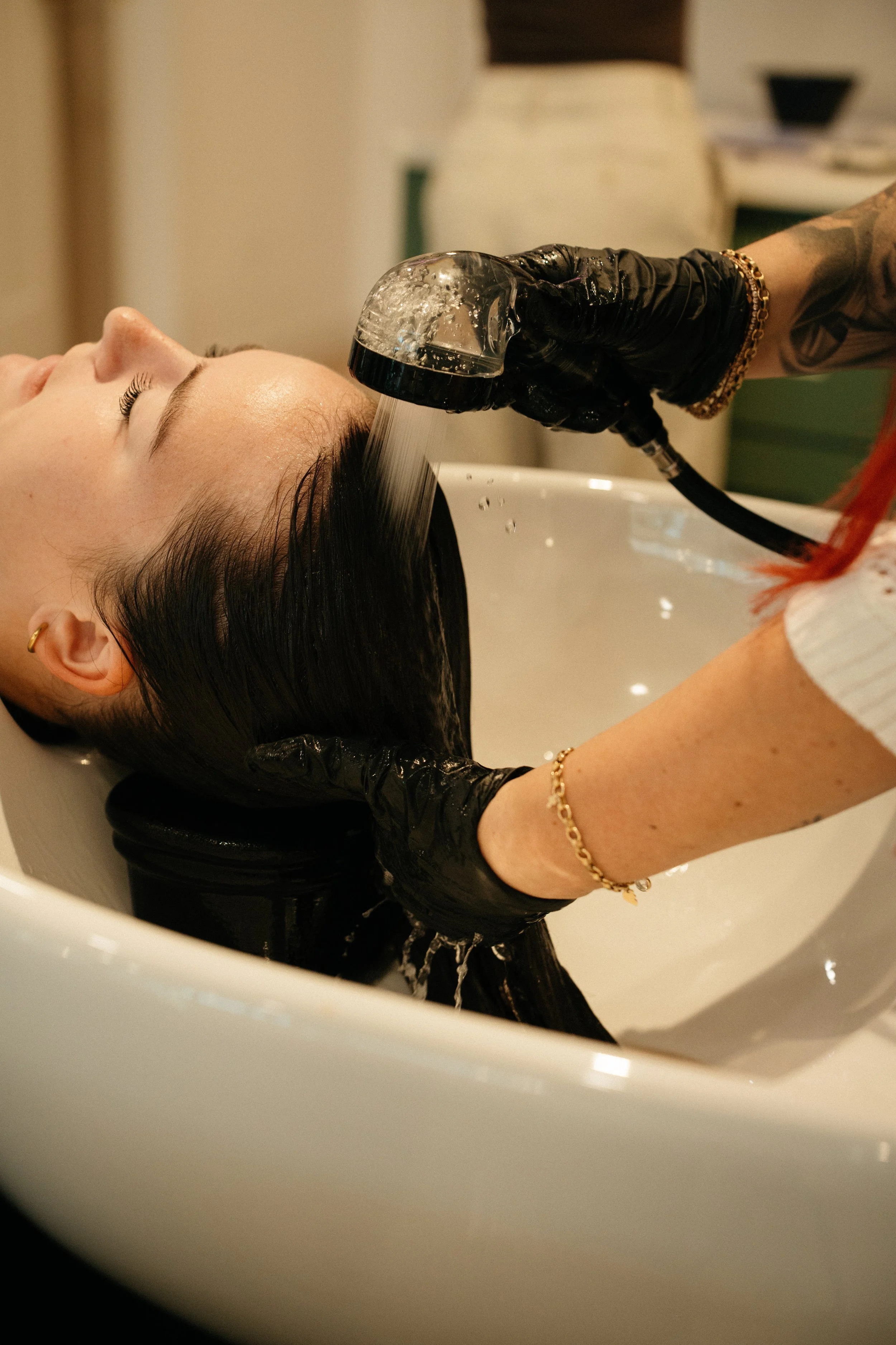 Hairdresser shampooing client in a shampoo bowl Hair dye Highlights.