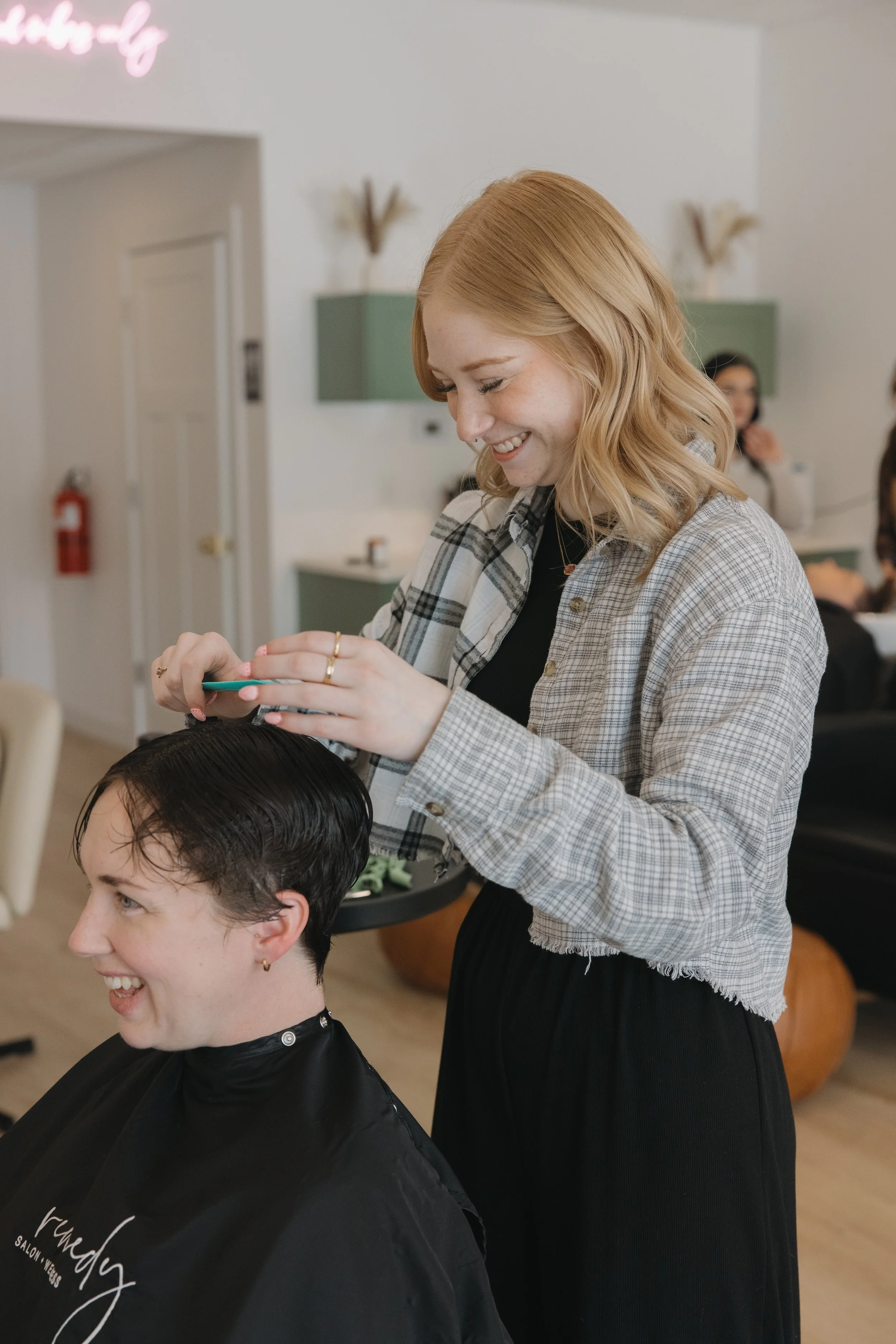 Hair salon technician cutting a client's hair during a haircut session at a modern hair salon.